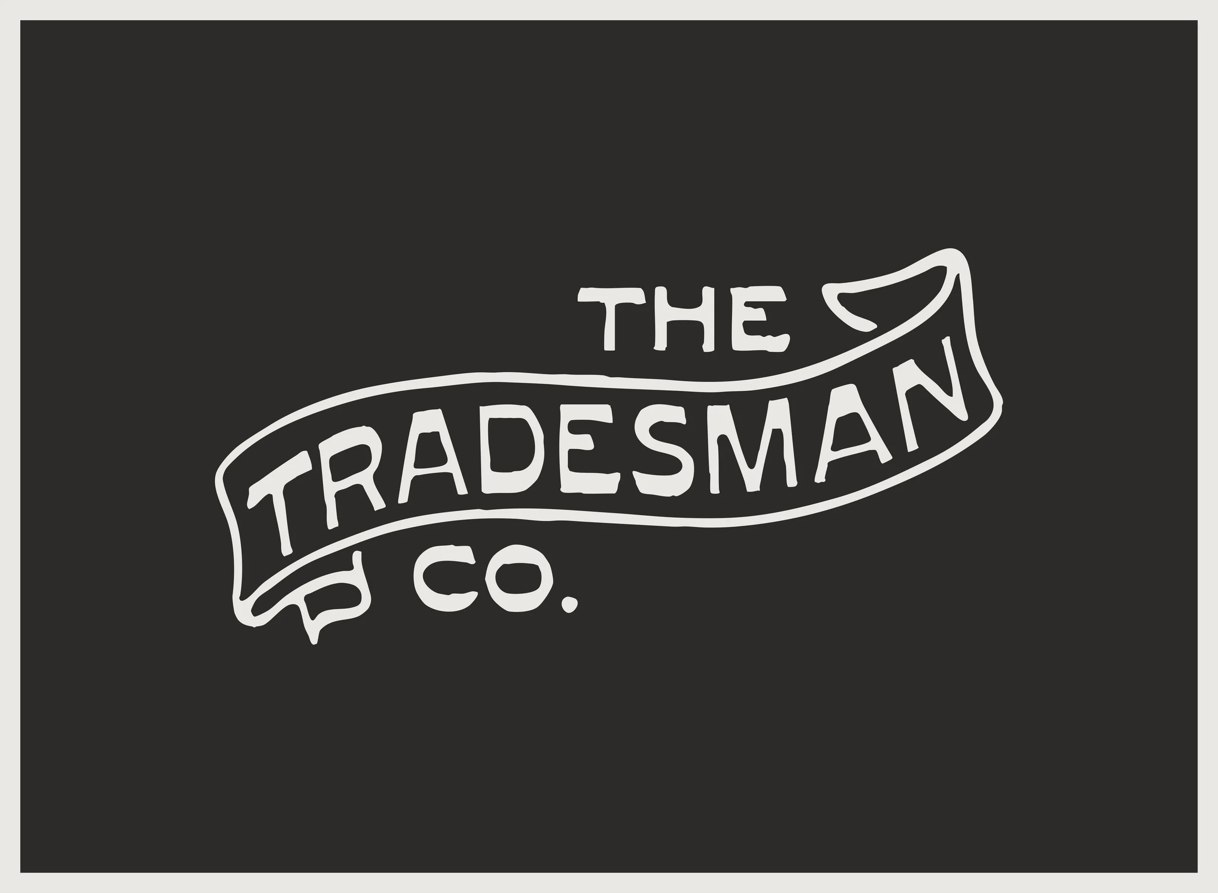 The logo of The Tradesman Co. in white on a black background, with a ribbon banner style design.