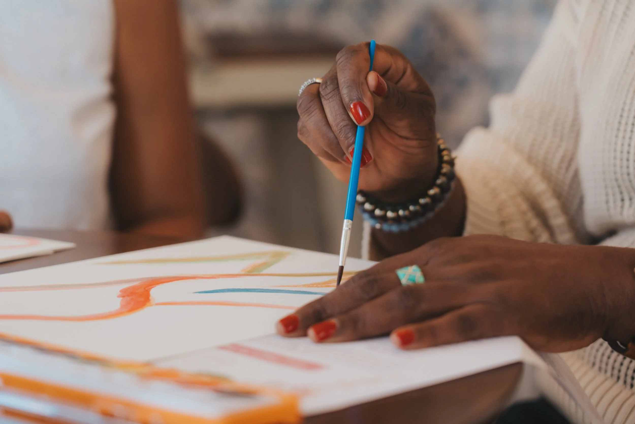 Meg Charles leading a creative painting session representing personal growth and self-expression