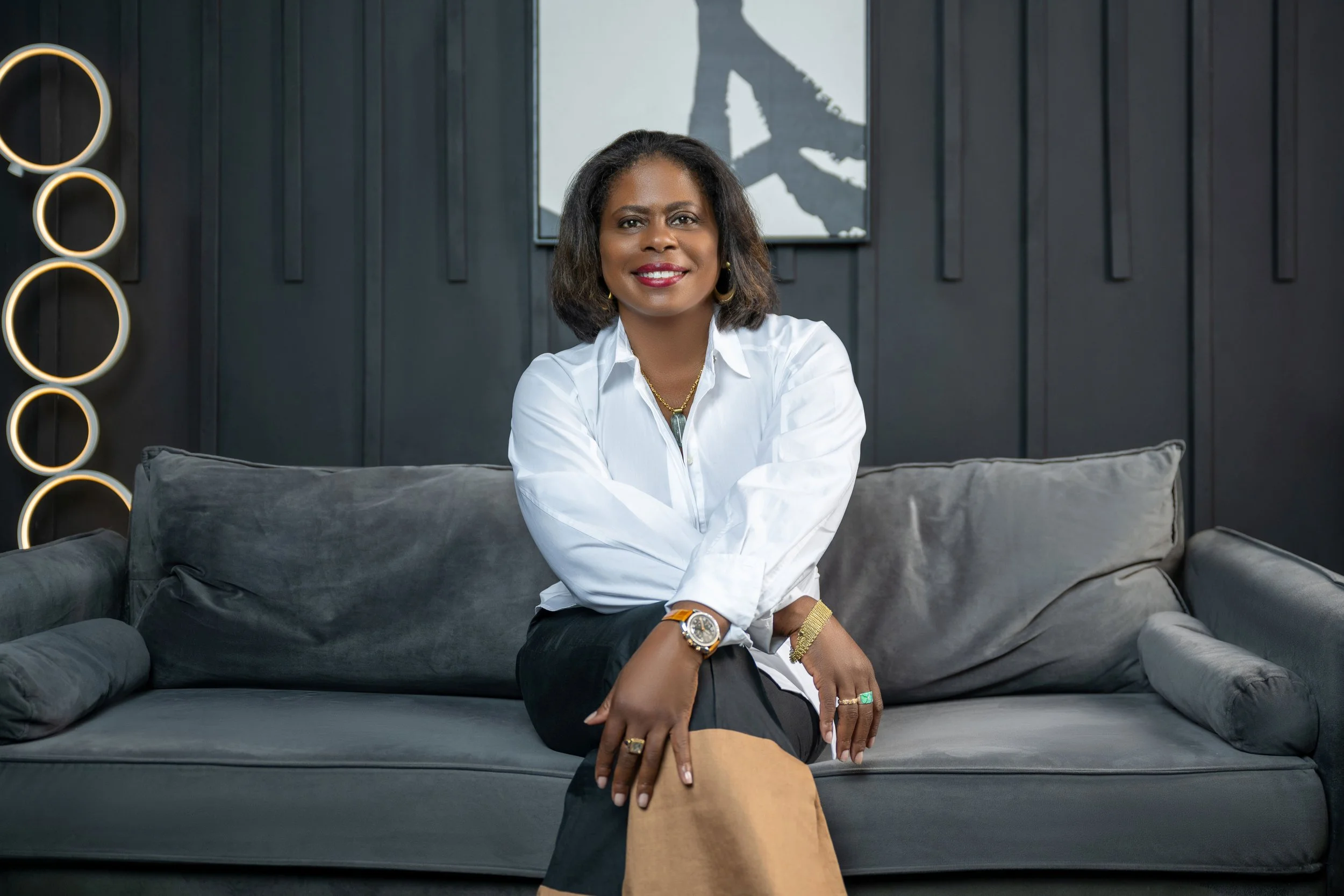 Meg Charles seated portrait representing approachable leadership, strategy, and professional confidence