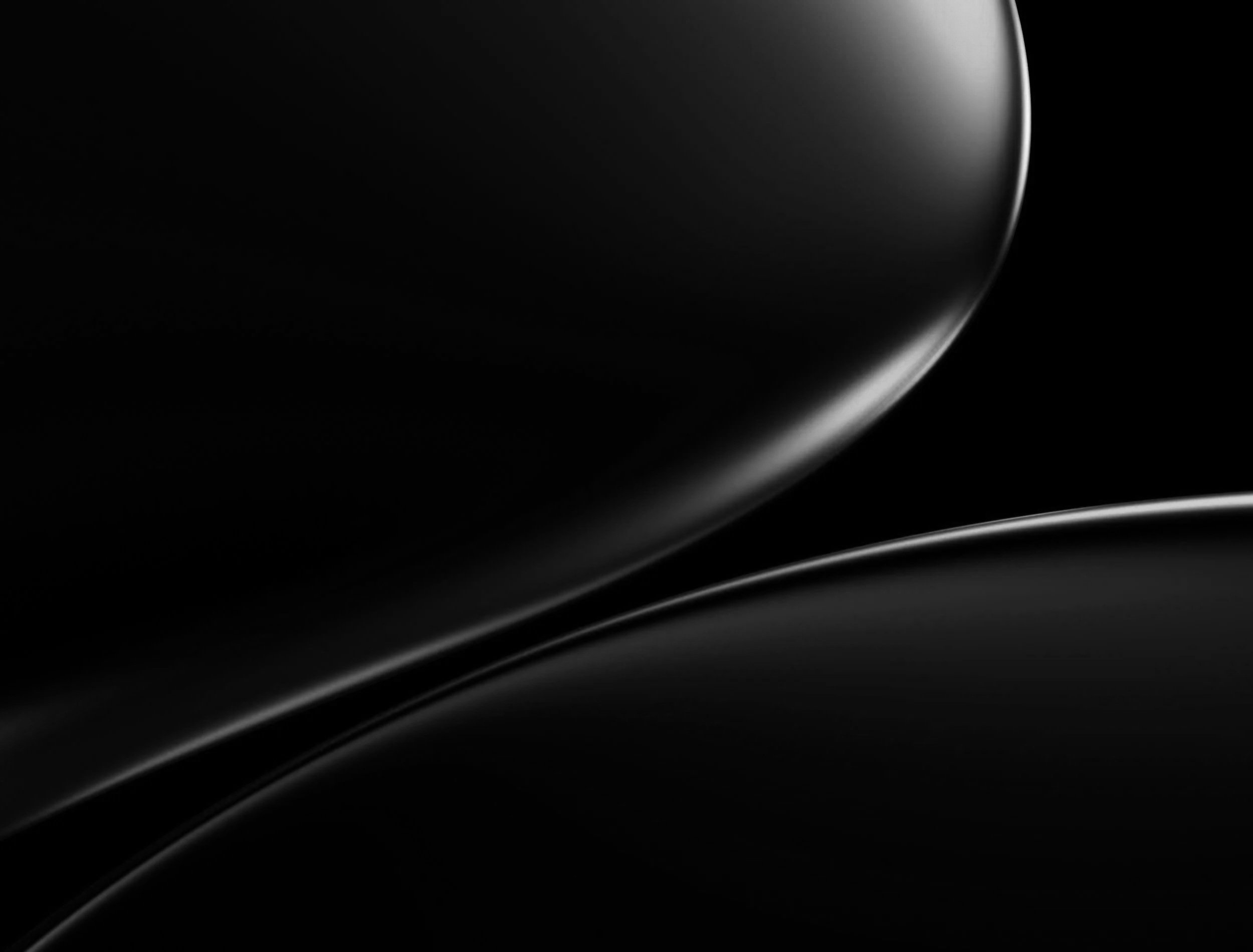 Abstract black background with smooth, curved, shiny surfaces and soft highlights.