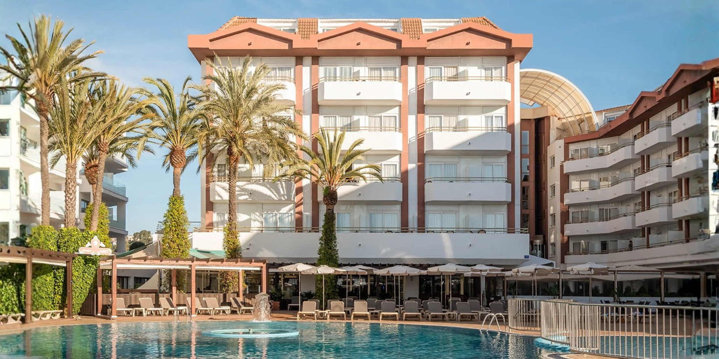 façade de l'hotel au soleil vue de la piscine