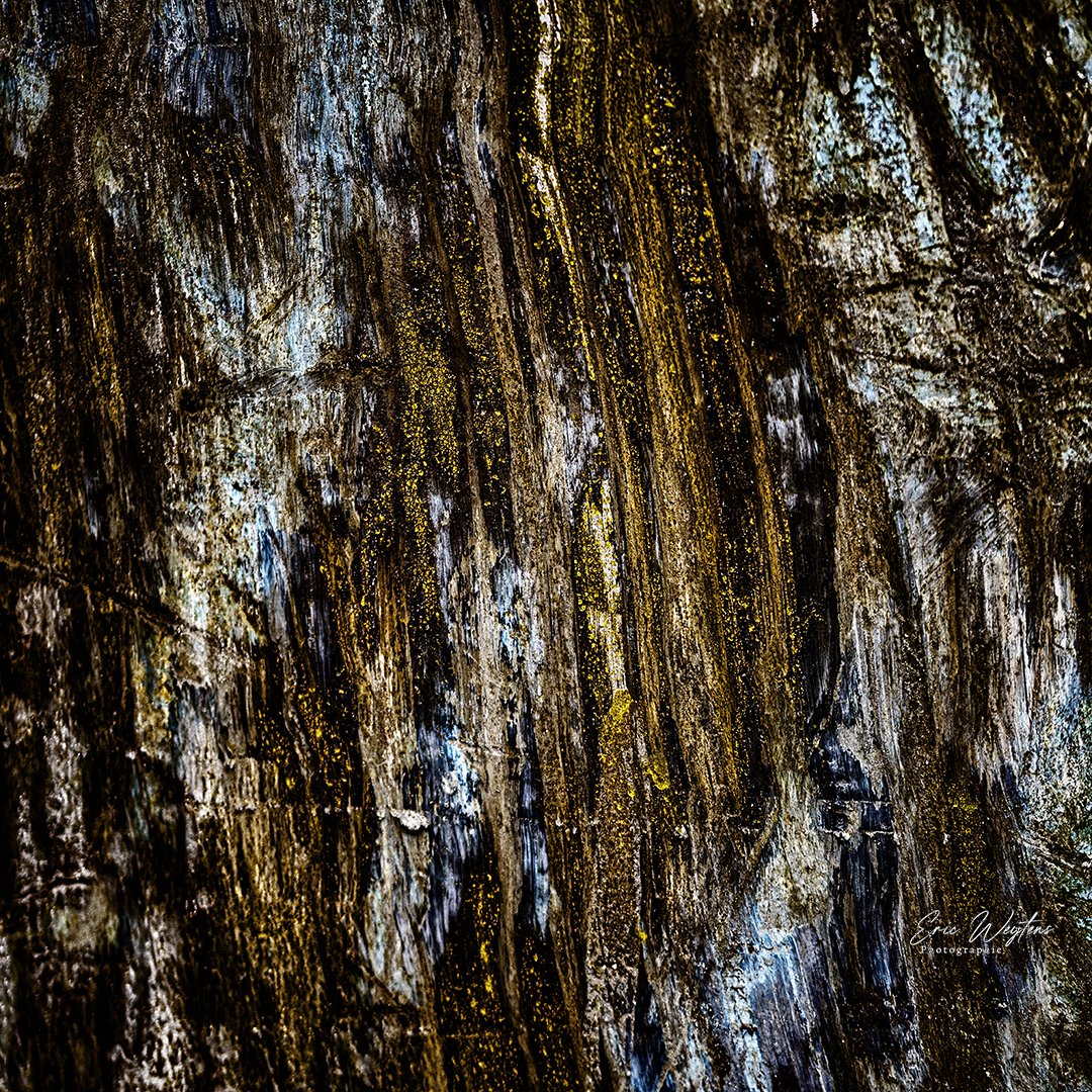 Texture d'une plaque de métal avec des touches de bleu, de jaune et de brun.