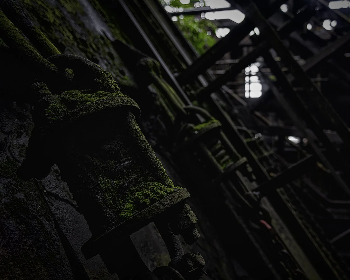 Vieux robinet en fer recouvert de mousse dans un bâtiment abandonné.
