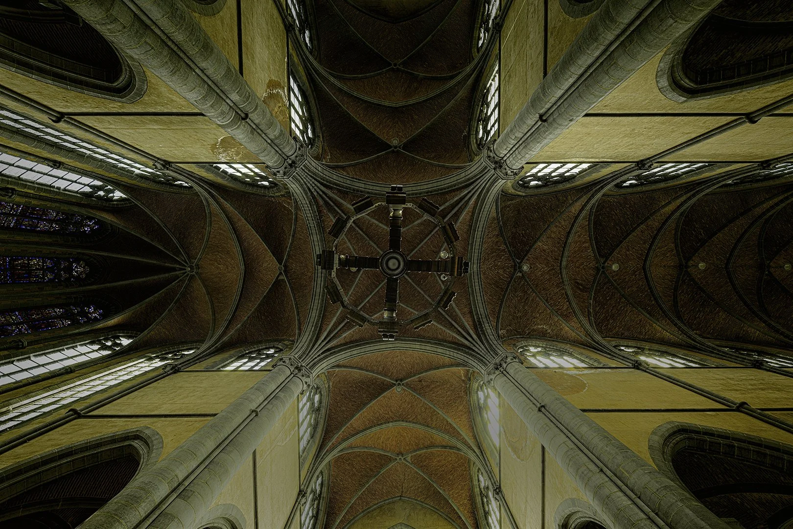 Intérieur d'une cathédrale gothique, vue du sol vers le plafond, avec des colonnes en pierre et une voûte en arcs.