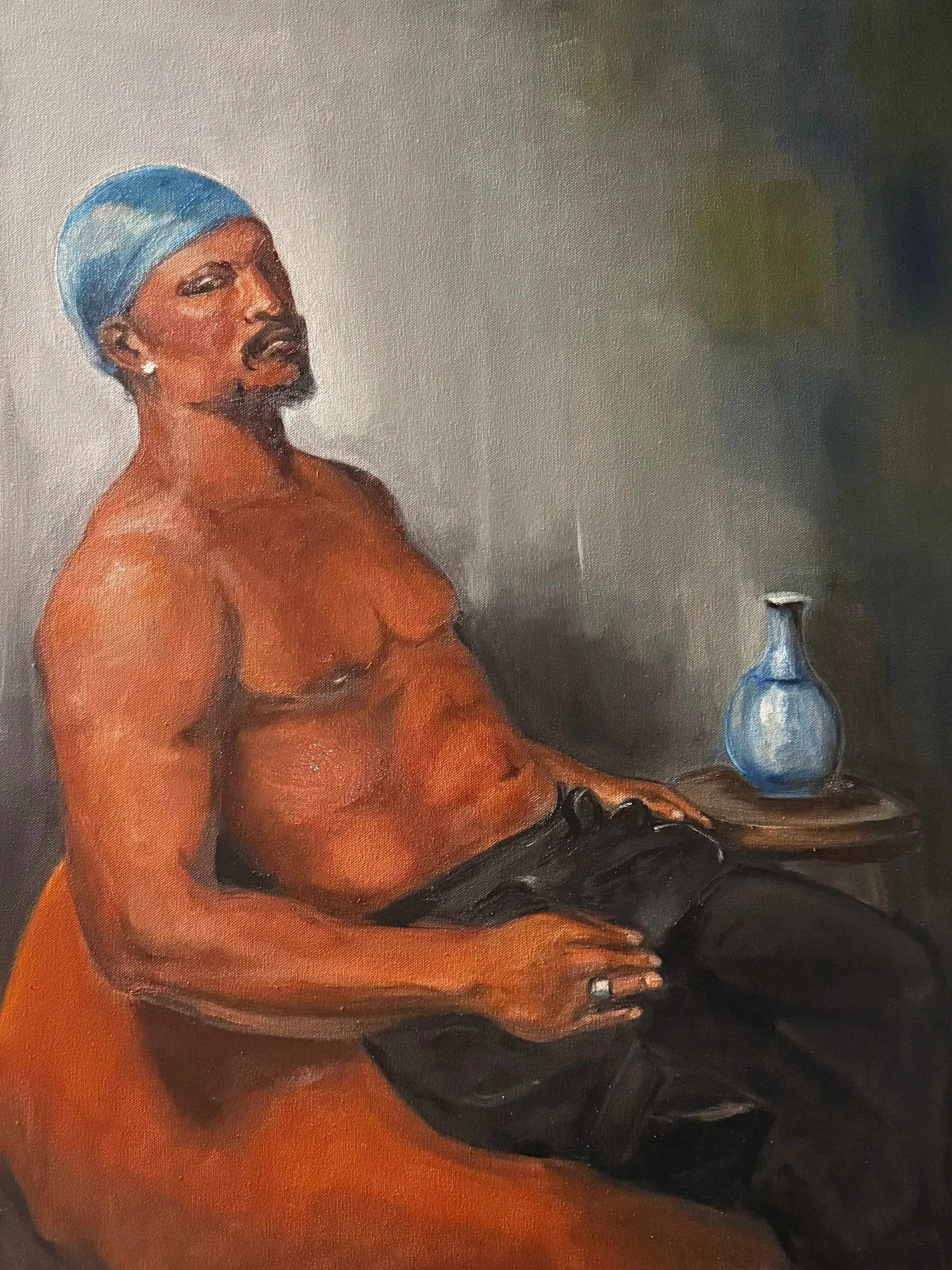 Painting of a shirtless man wearing a blue headscarf, earrings, and a ring, sitting on a chair, with a blue vase on a side table.