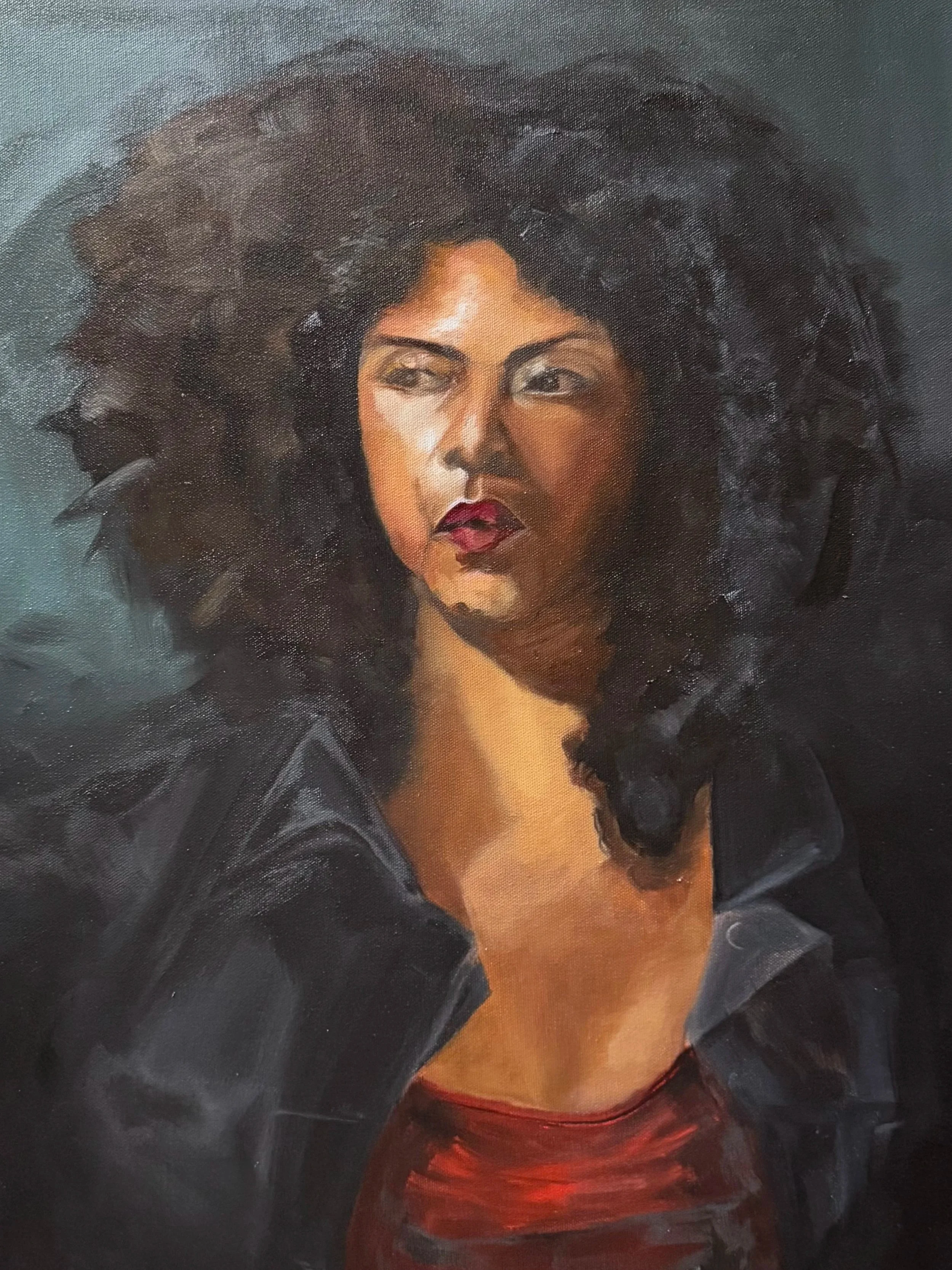 A portrait of a woman with dark curly hair, wearing a black jacket over a red top, looking off to the side with a serious expression.