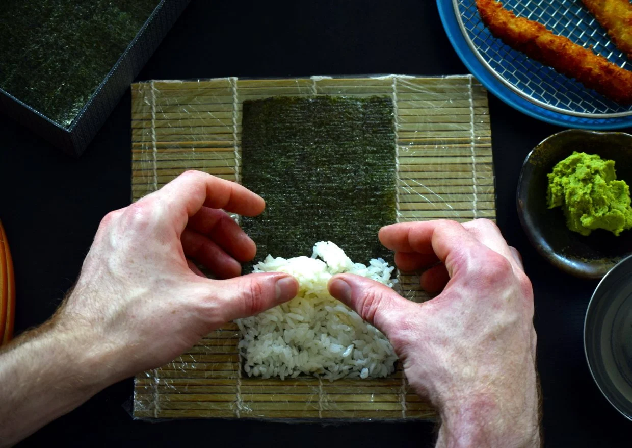 placing the rice onto the nori to make maki sushi