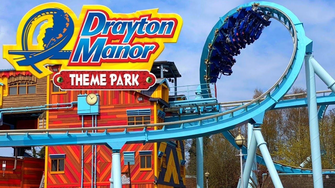 Colorful roller coaster at Drayton Manor Theme Park with the park's sign visible in the foreground.