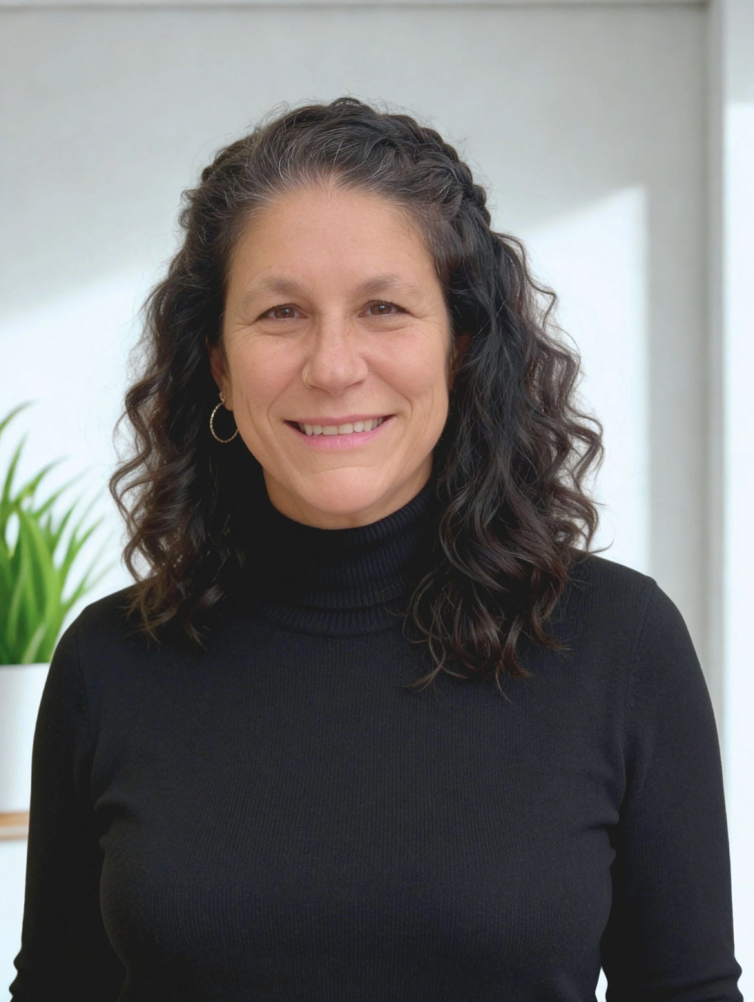 Jennifer Seifert attorney smiling indoors with a plant in the background.