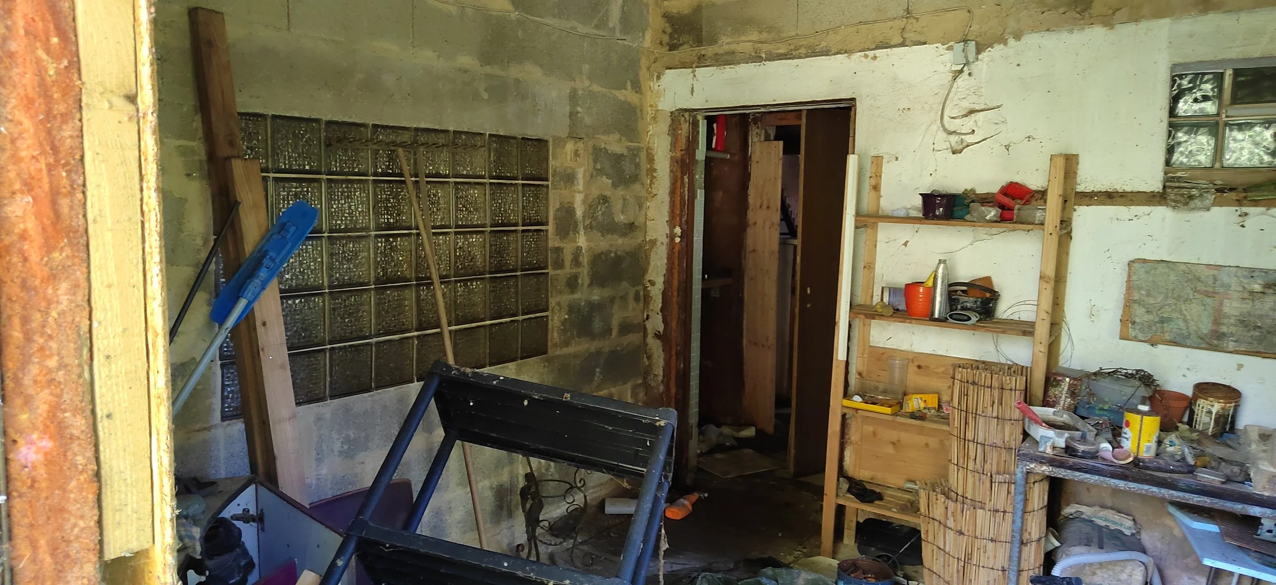 Ein unordentliches Werkstattraum mit Werkzeugen, Regalen, und Bau materials.