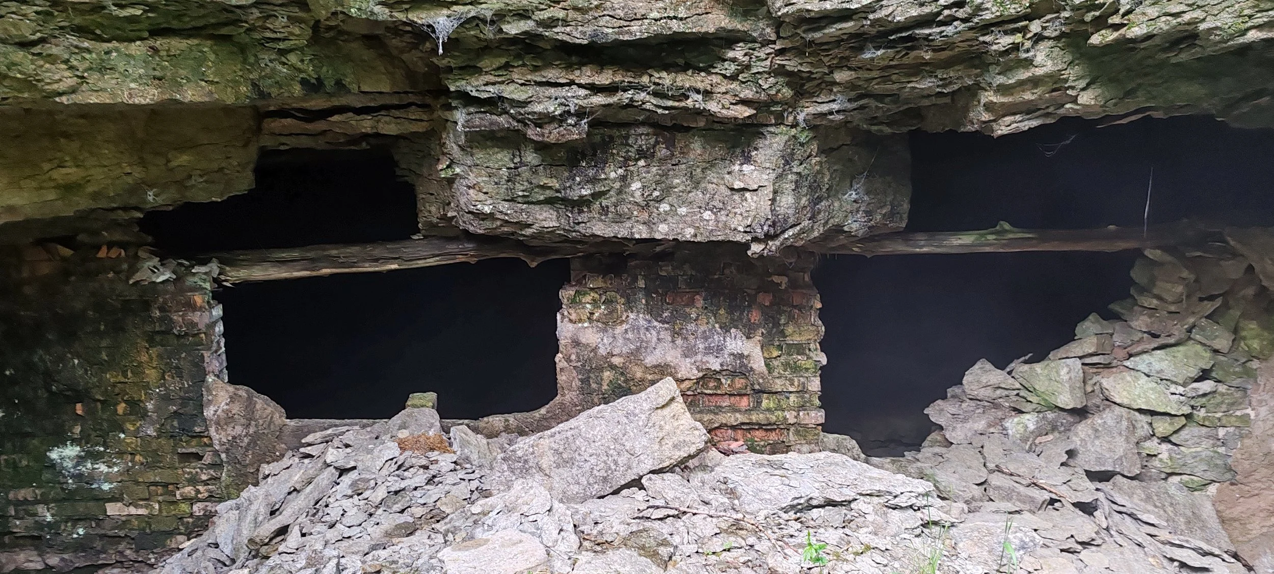 Alte verfallene Gebäude mit Bruchsteinen und offenen Fenstern, umgeben von zerbrochenem Steinmaterial.