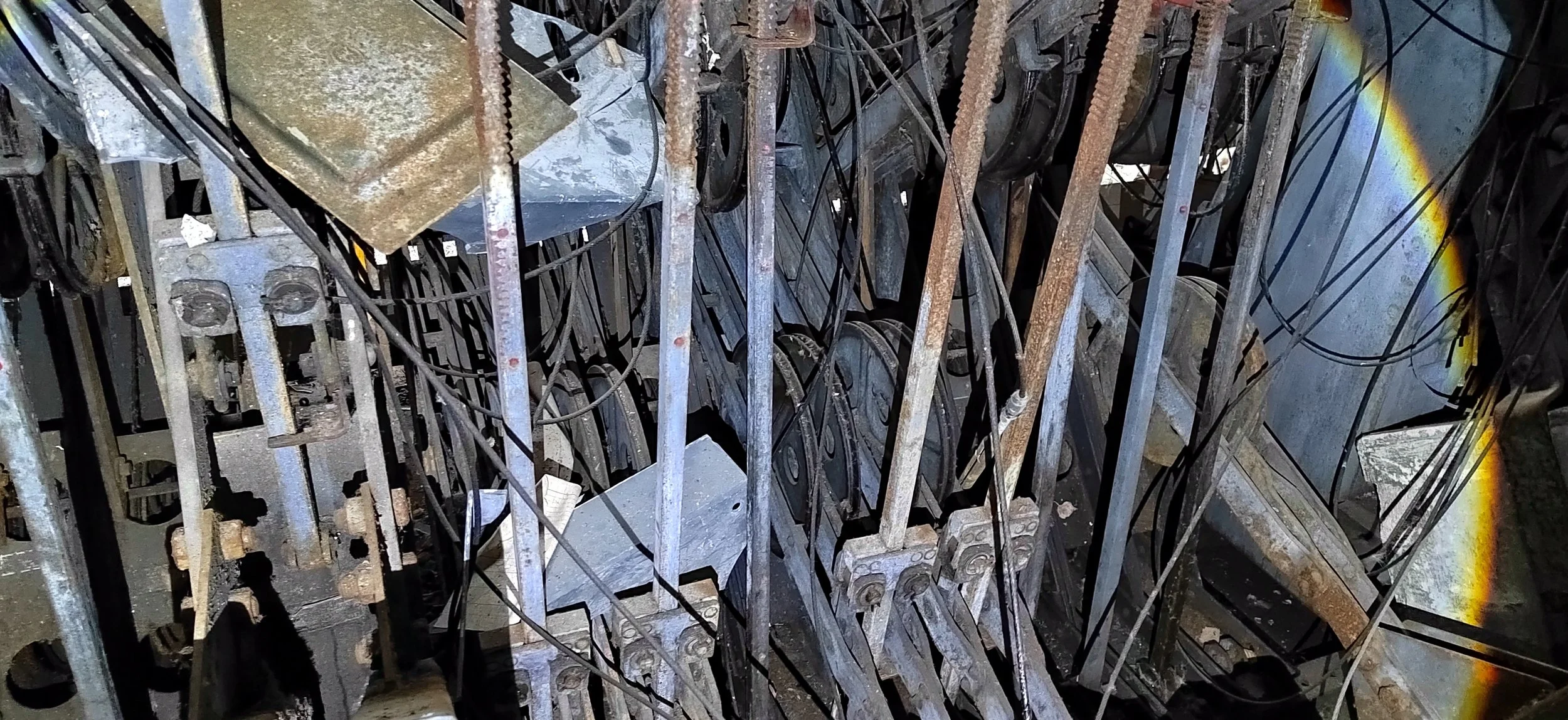 Verschroffene und rostige Metallteile, Kabel und Rahmen in einem industriellen oder wissenschaftlichen Umfeld.