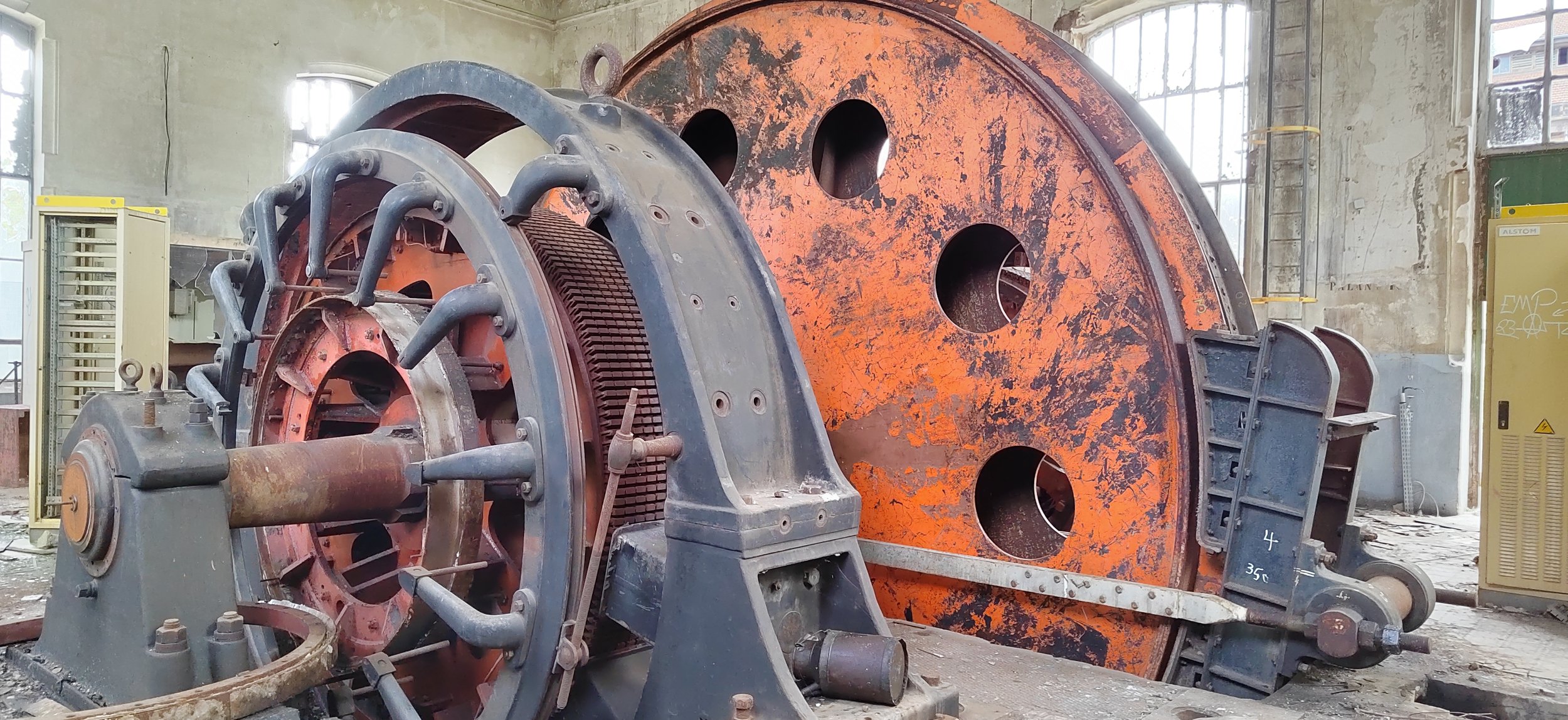 Große alte Maschinen und Reifen in einer Fabrikhalle.