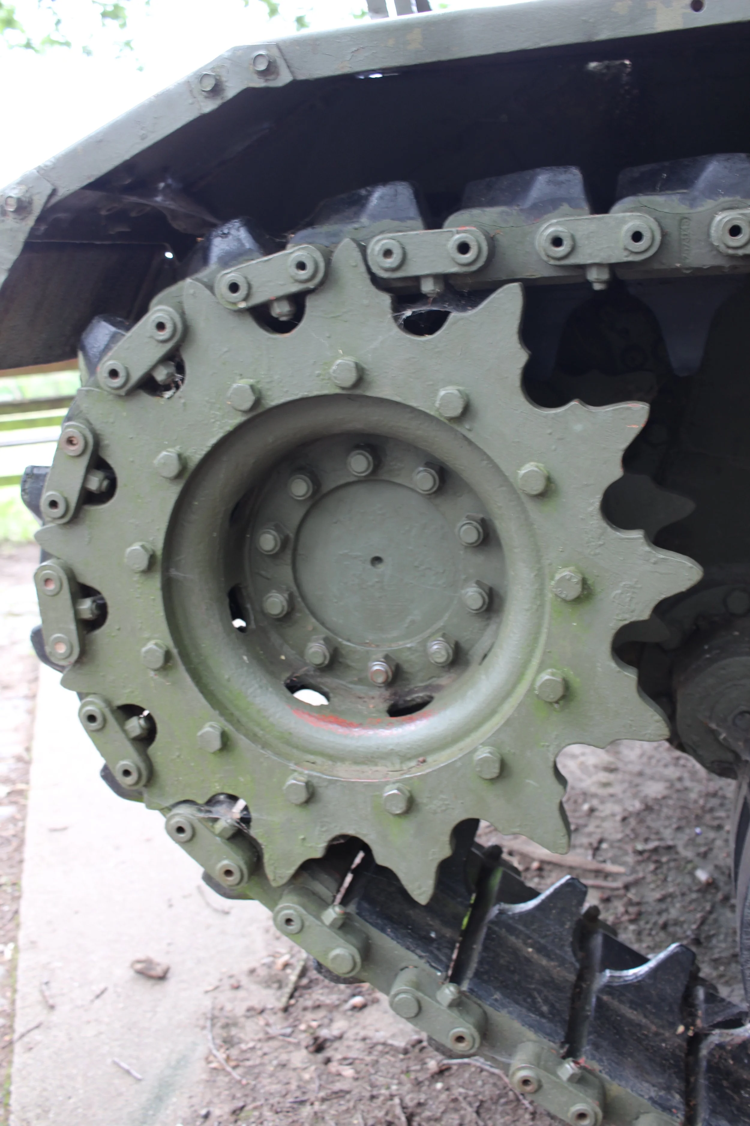 Nahaufnahme eines Panzerkettenritzels mit Kette und Zahnrädern.