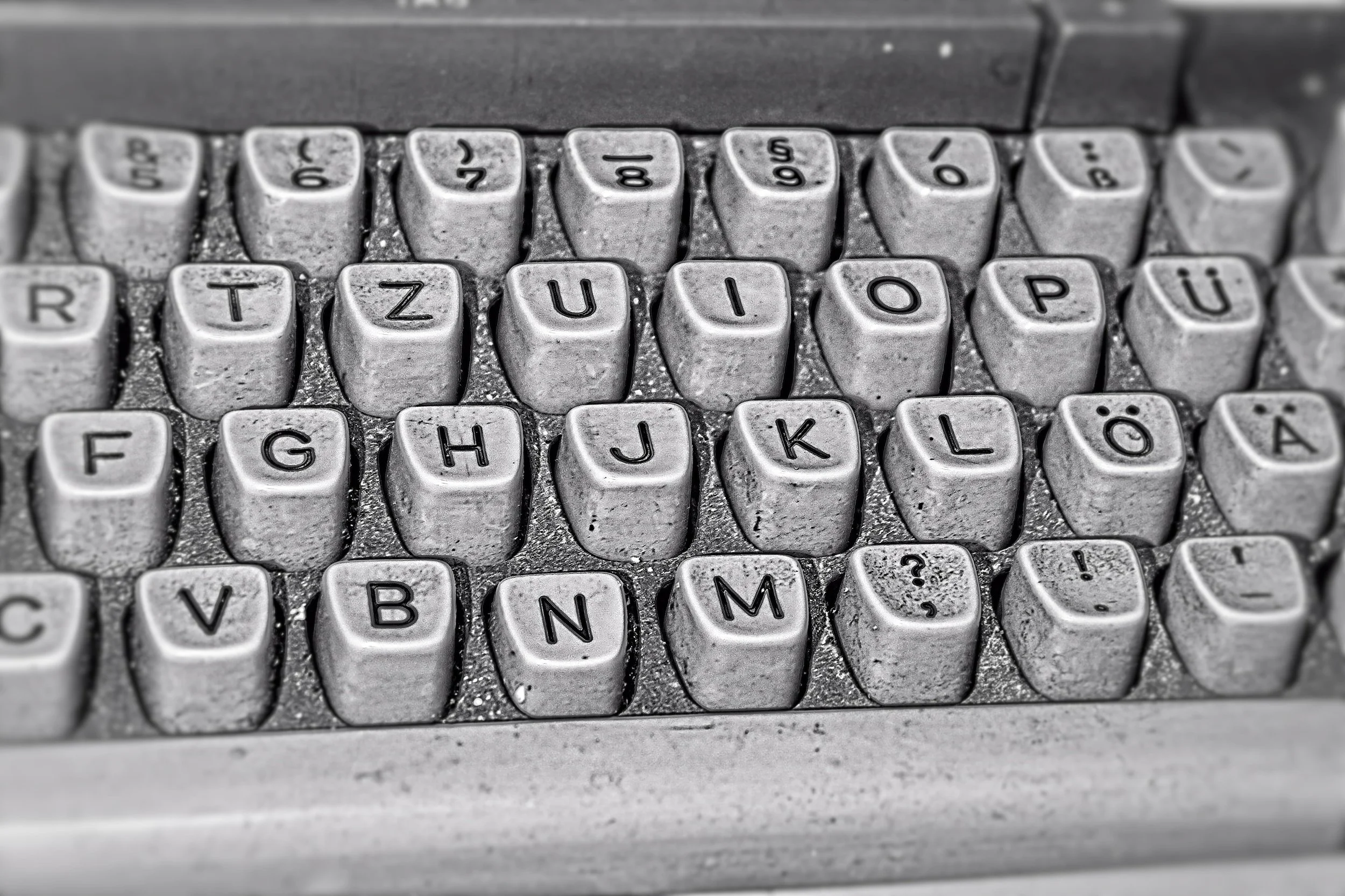 Nahaufnahme einer alten, verschmutzten deutschen Computertastatur mit Staub und Schmutz auf den Tasten.