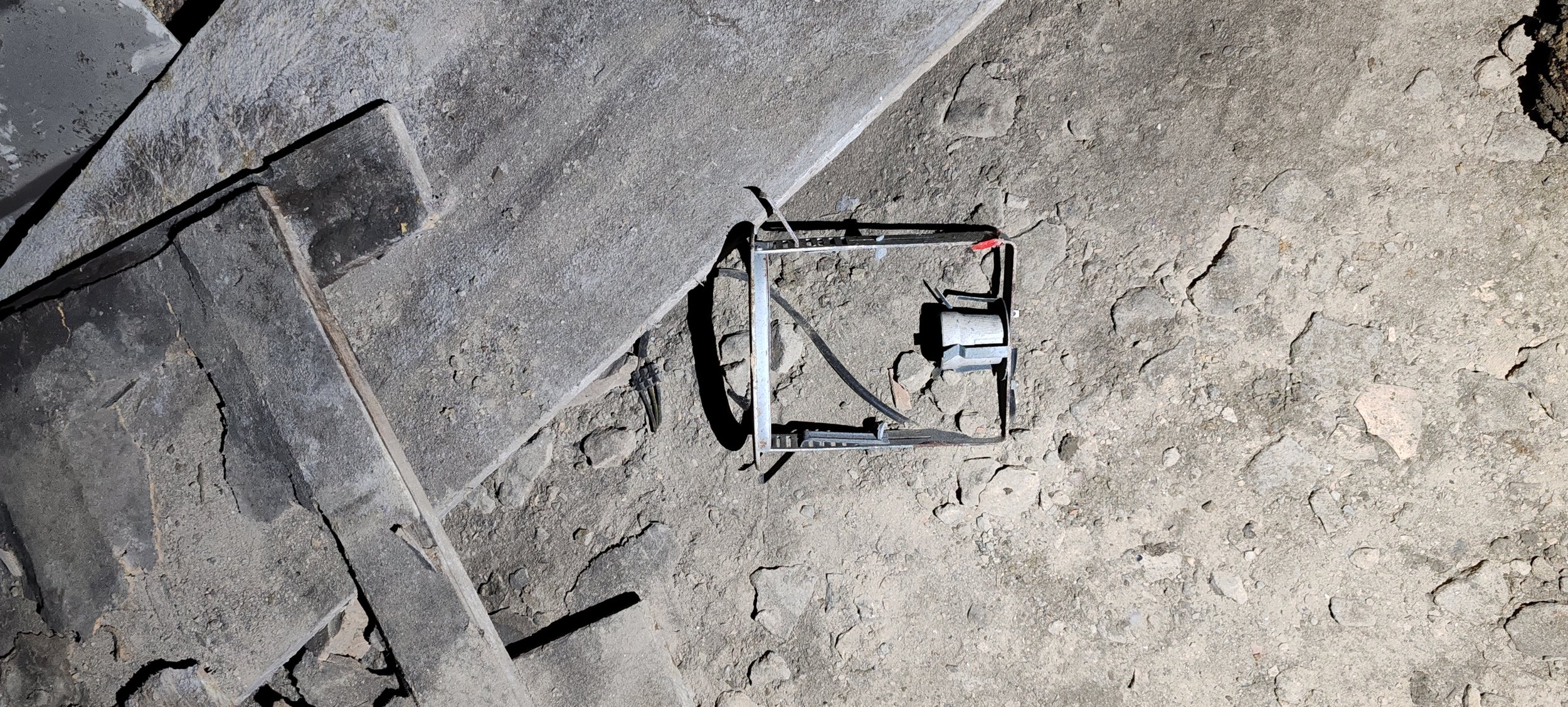 Boden und eine abgestellte Werkzeugkiste auf einer Baustelle, im Hintergrund unebener Boden.