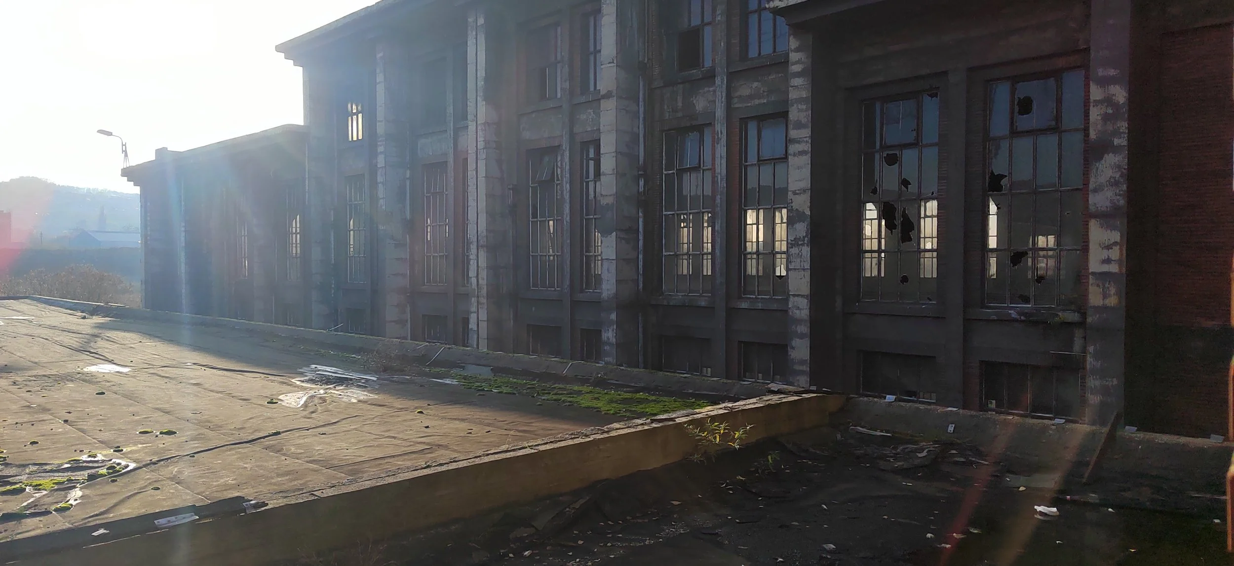 Verfallenes, beschädigtes Gebäude mit zerbrochenen Fenstern im Sonnenlicht