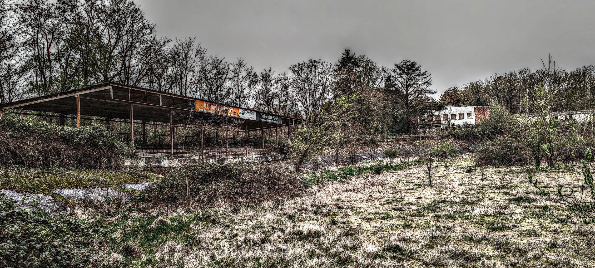 Verfallene, verlassene Bahnstation im Grünen, Bäume und Nebel, düstere Stimmung