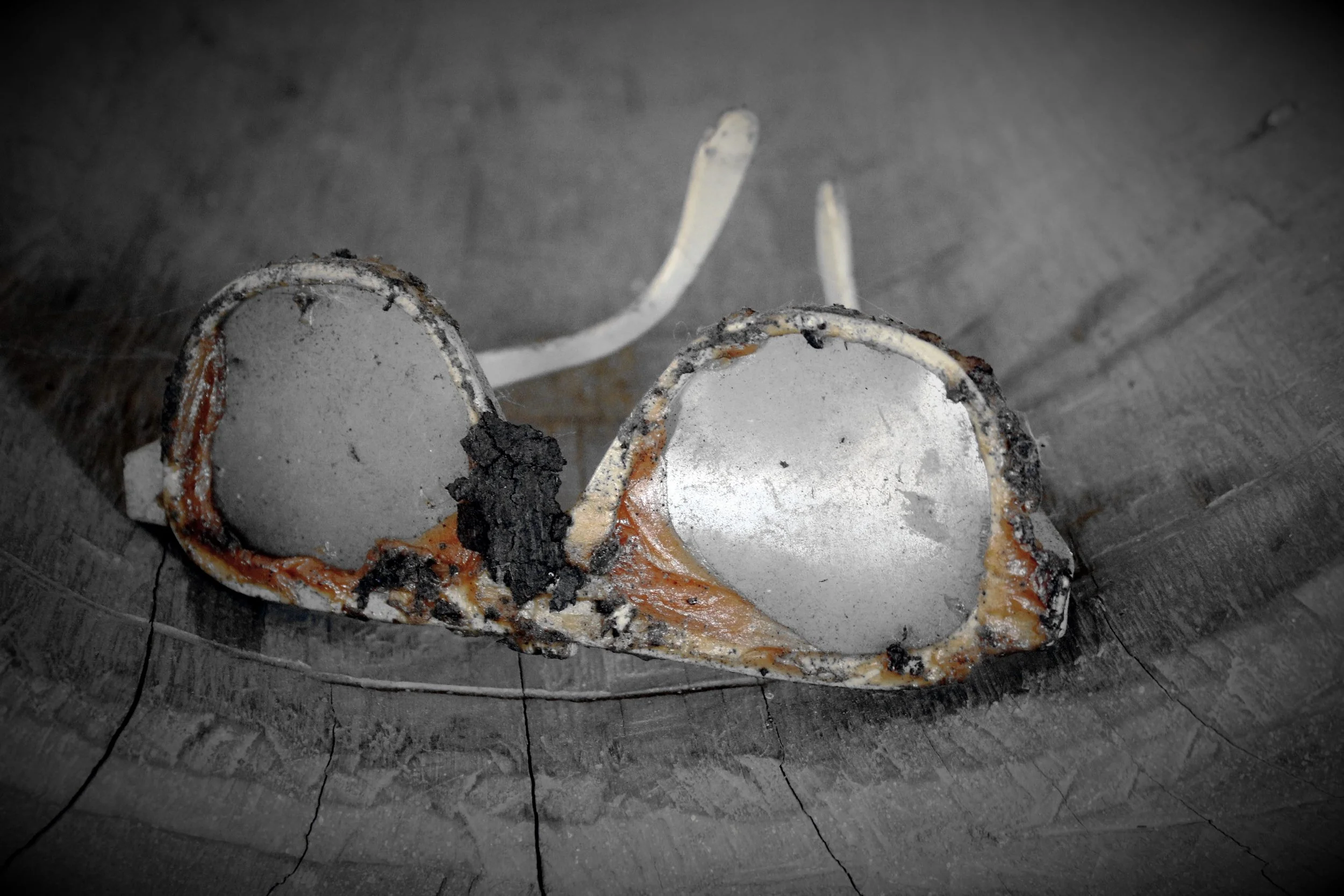 Verbrannte, zerbrochene Glühbirne auf einem Holzstück