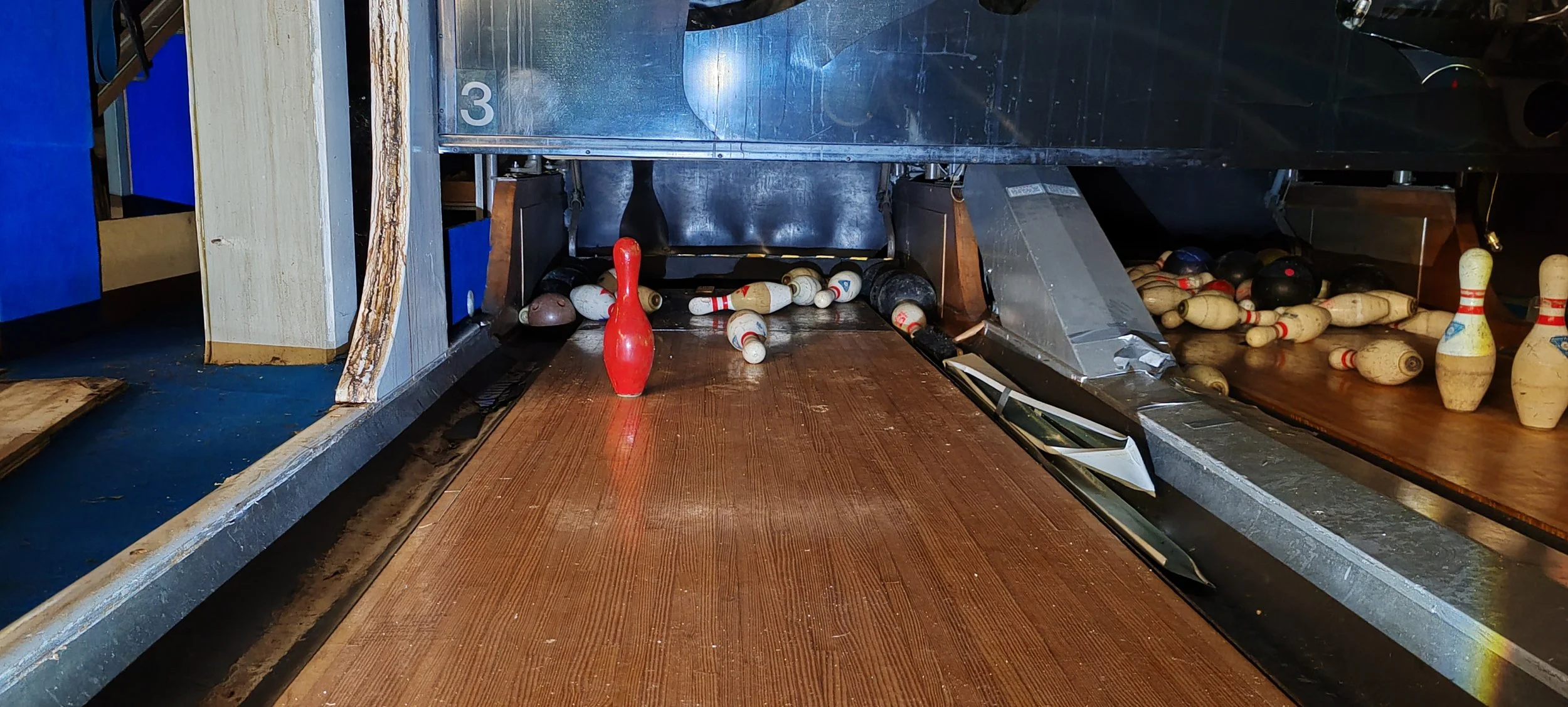 Zusammengebrochene Bowlingkugeln nach einem Wurf in einer Bowlingbahn.