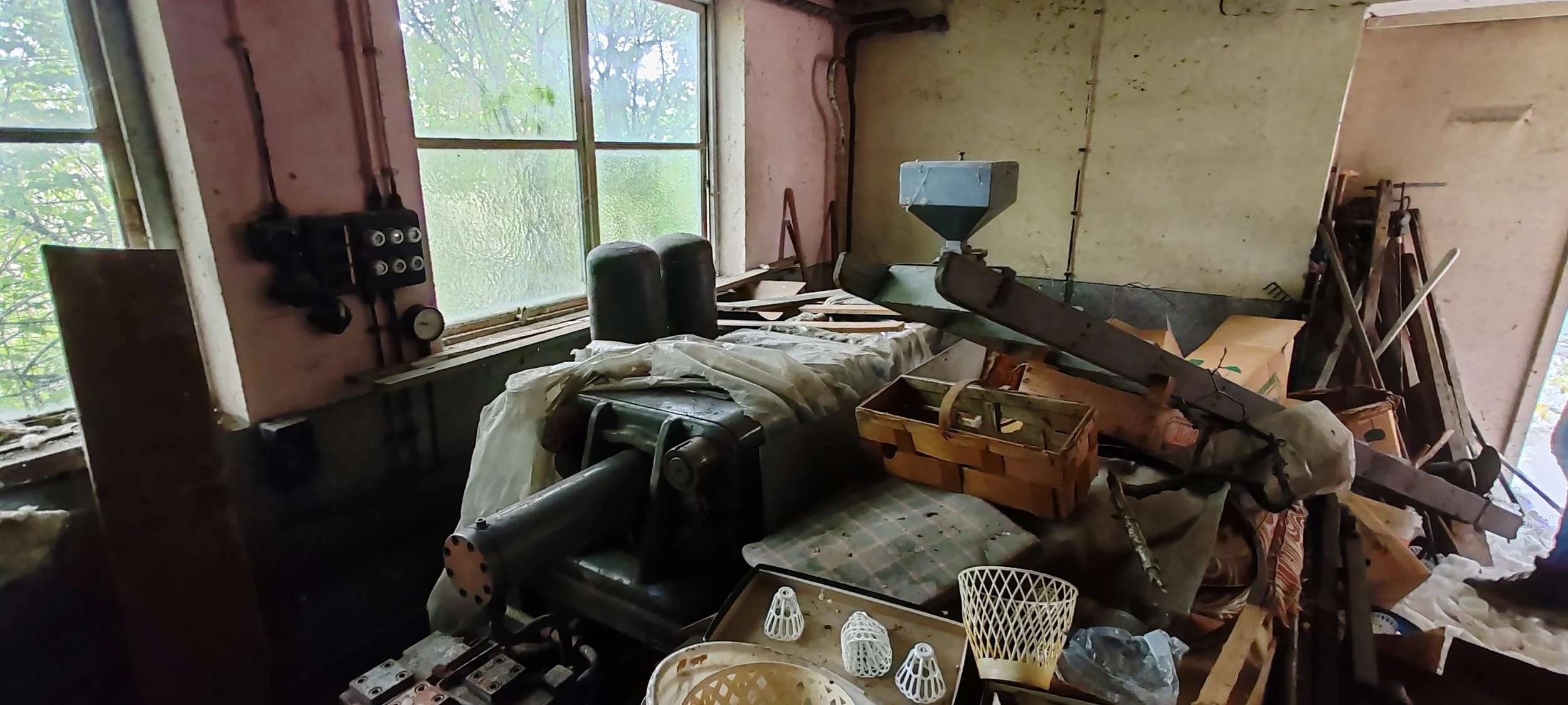 Ein Staubiges, unordentliches Zimmer mit einigen Werkzeugen, Büchern, Holzstücken und einem alten Flugscheinflugmodell. Fenster lassen natürliches Licht hinein.