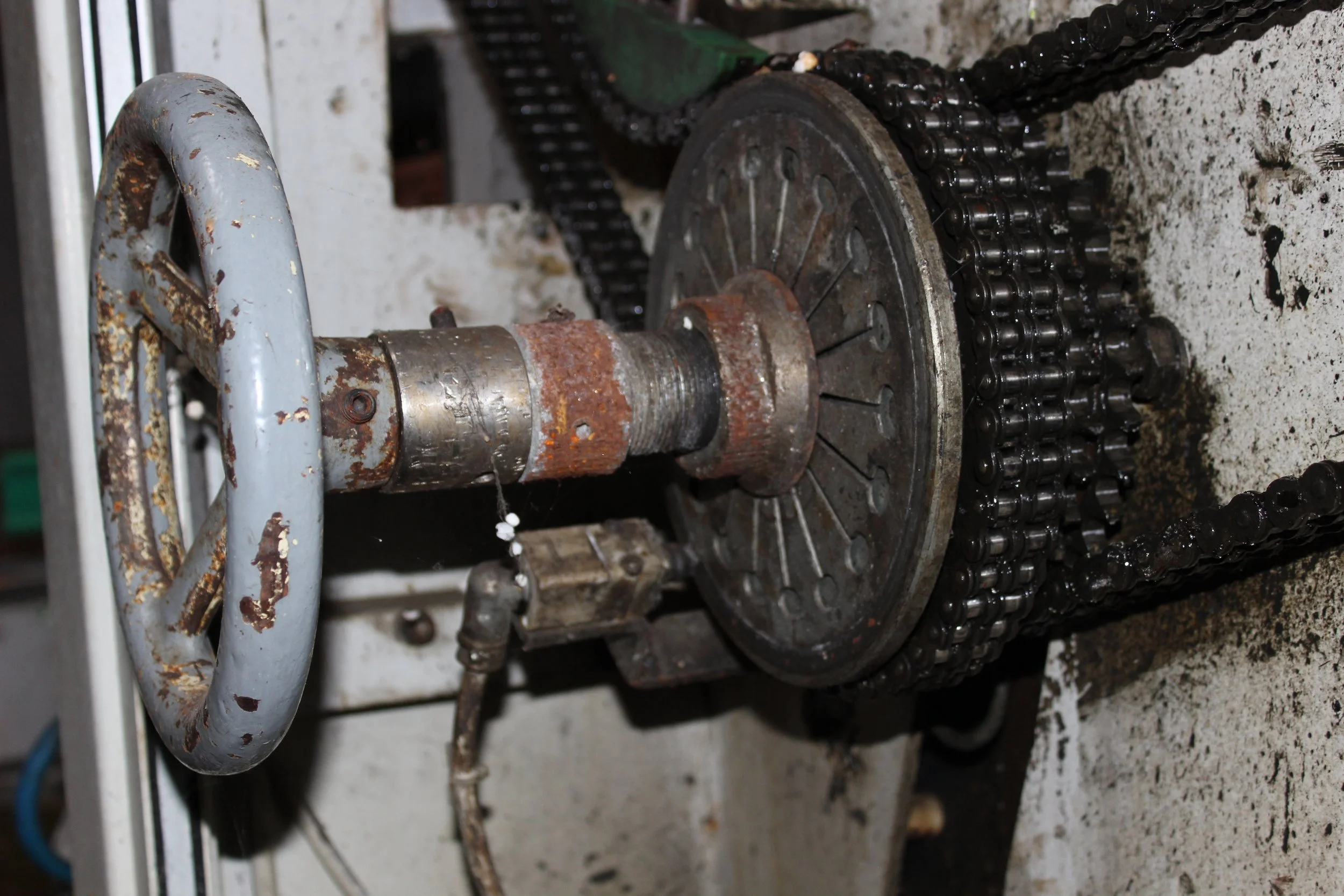 Eine alte, rostige Maschine mit gelenkigem Handrad und Ketten.