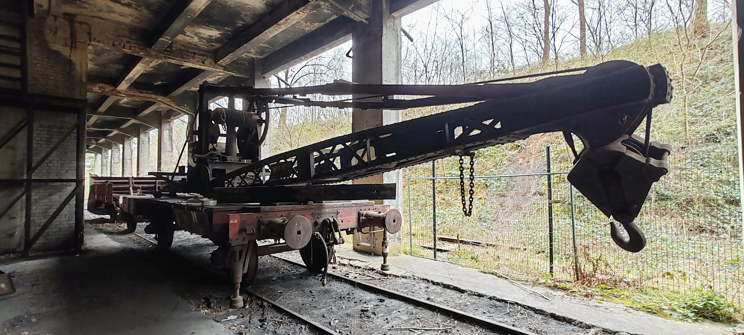 Alte Loren bei einem verlassenen Bahngelände, umgeben von Natur.