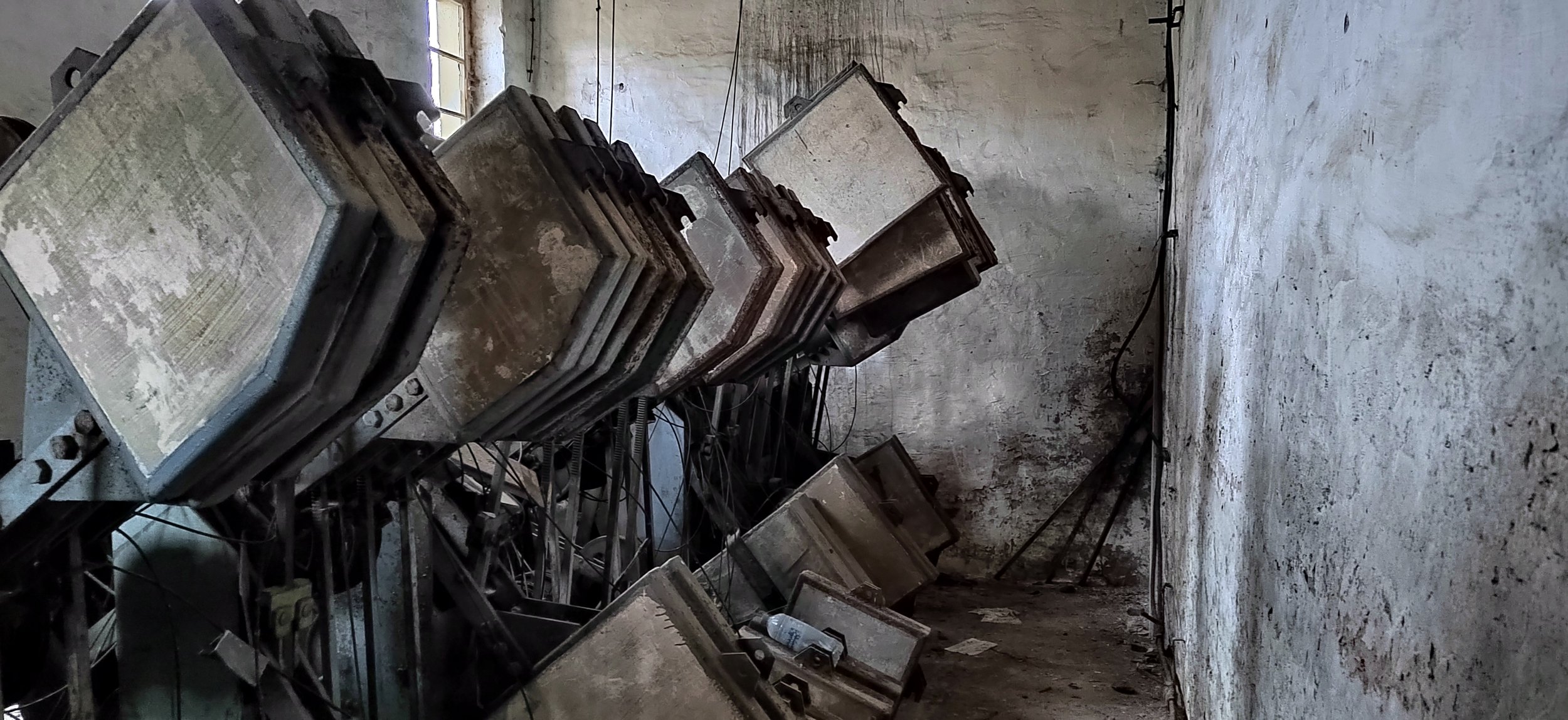 Dreckige, veraltete Computer-Überwachungsmonitore in einem verfallenen Raum, verstaubt und von Staub und Schmutz bedeckt.