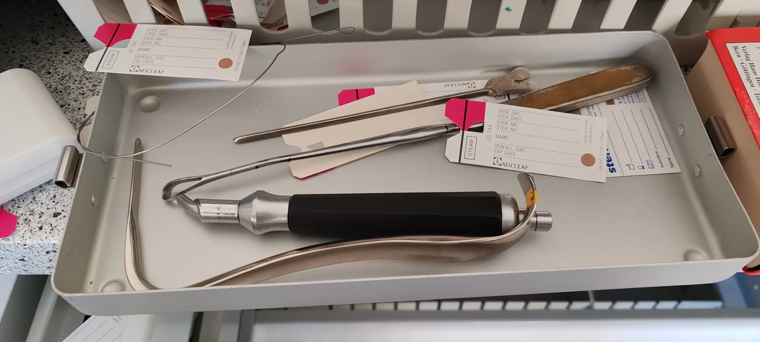 Chirurgische Instrumente, einschließlich Zange, auf einem medizinischen Tablett