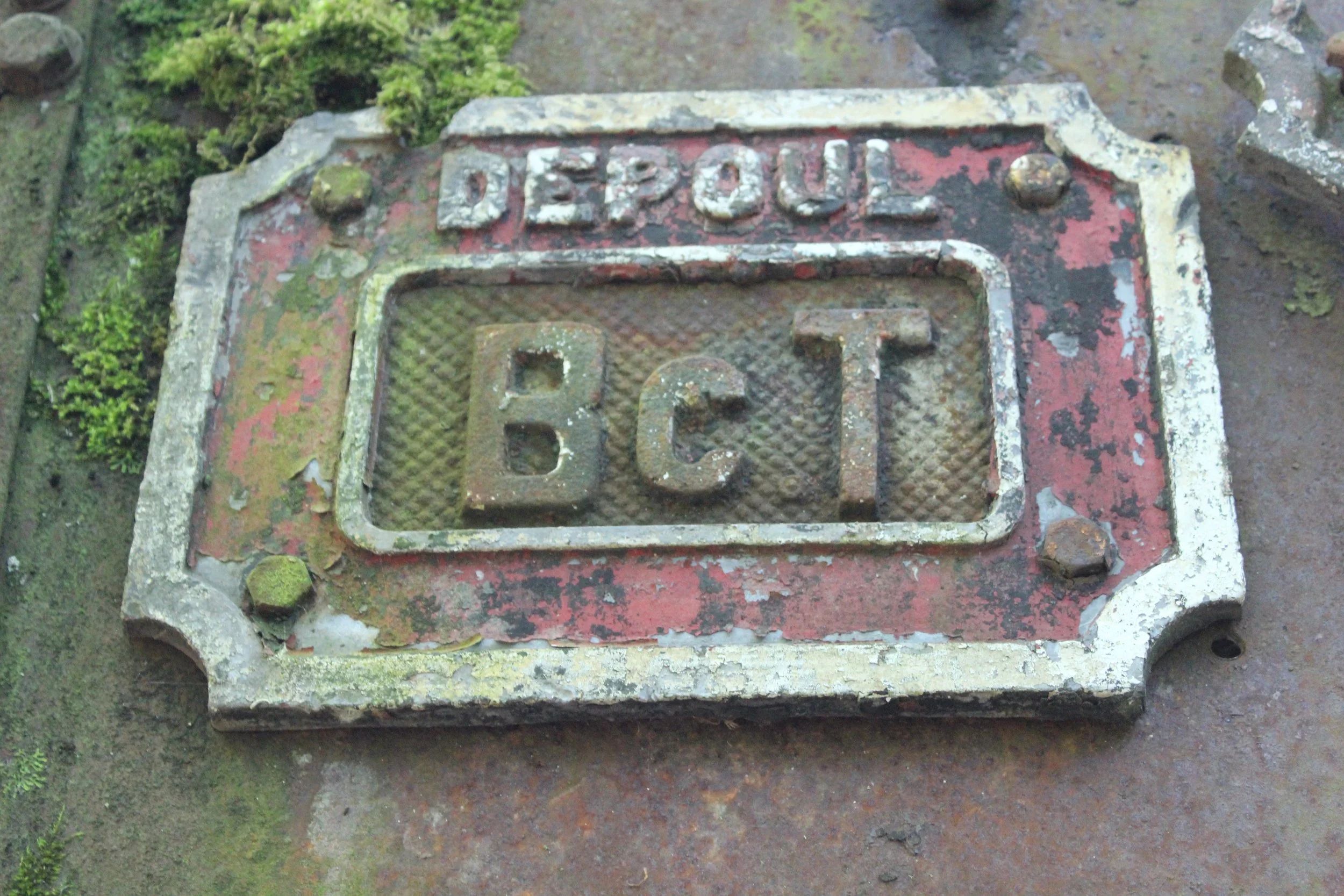 Altes, rostiges Signal- oder Schaltfeld mit der Aufschrift 'DEPOLL' und den Buchstaben 'BCT' in einer gedachten Umrahmung.