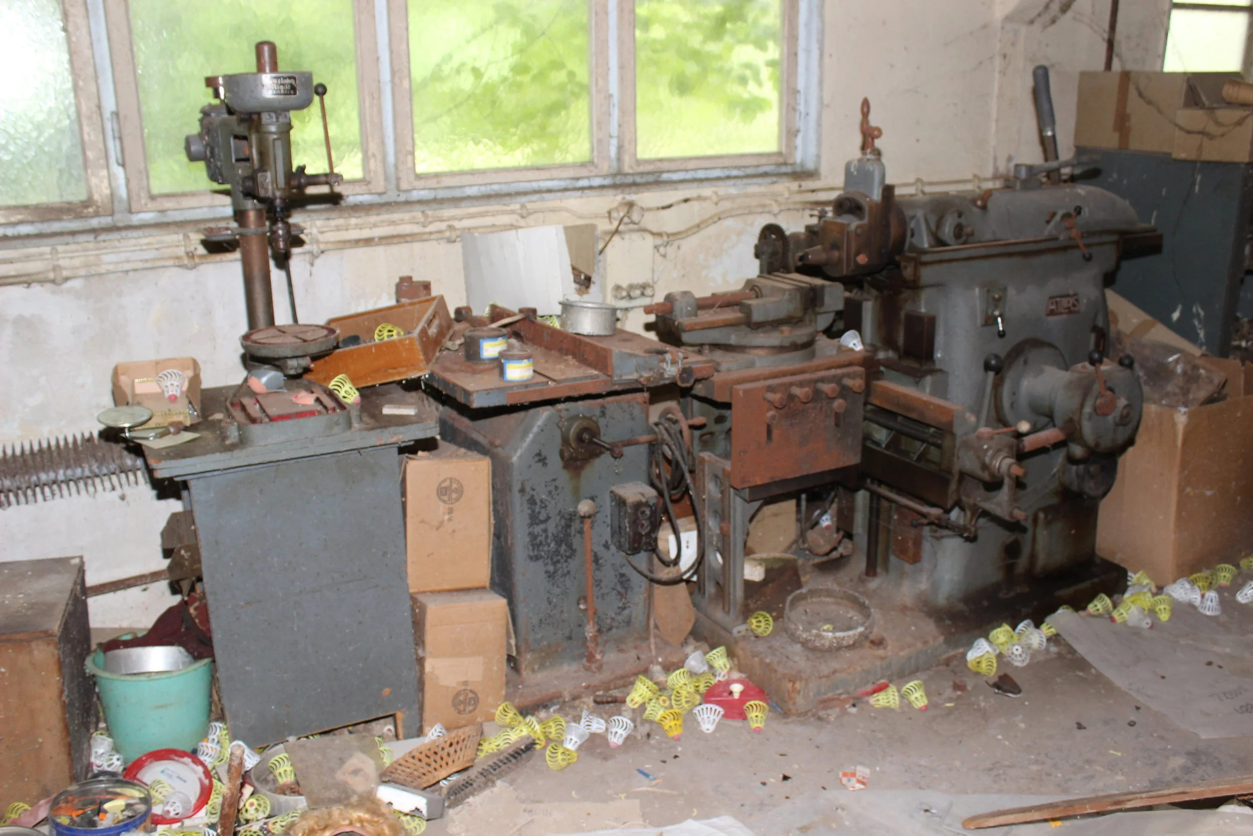 Alte, verrostete Werkzeugmaschine in einer Werkstatt mit Fenster