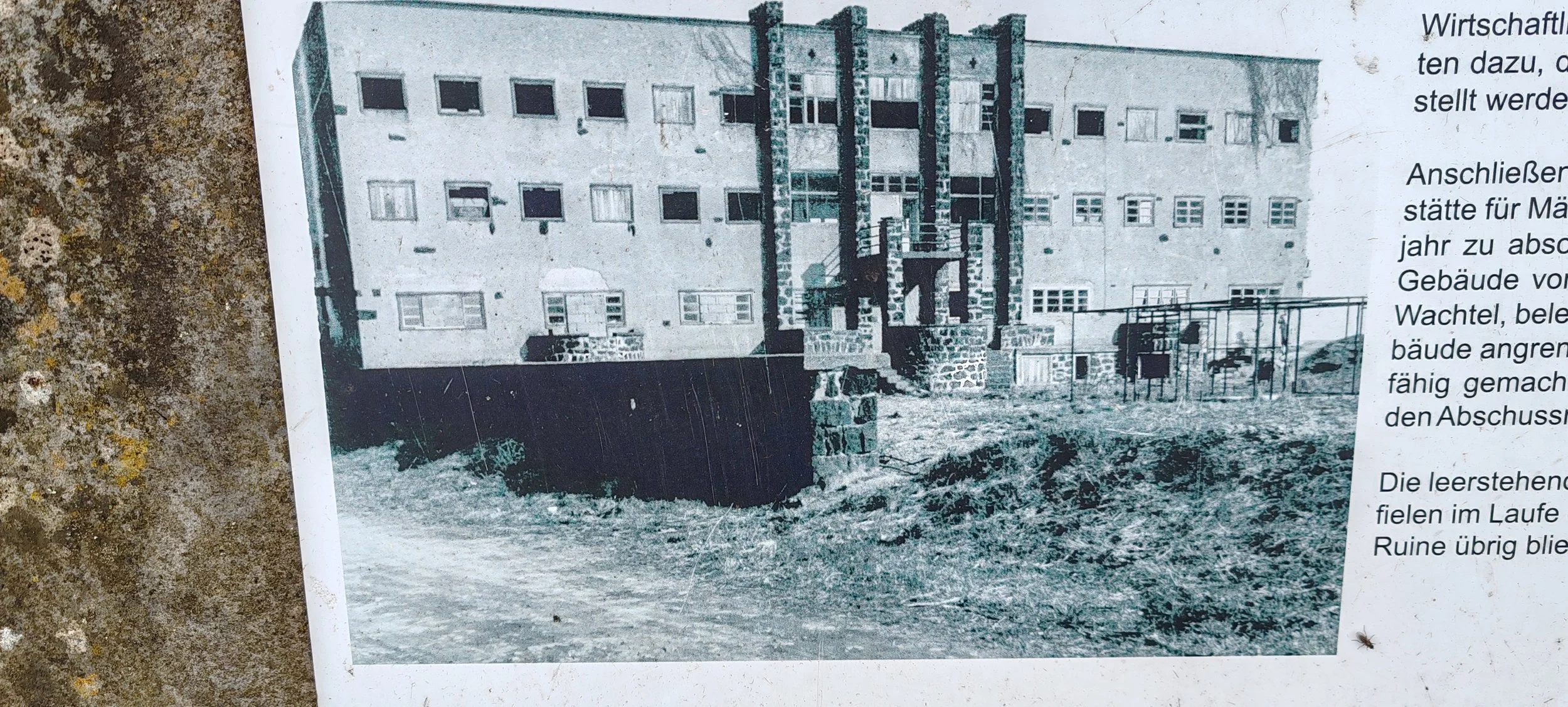 Ein altes, mehrstöckiges Gebäude mit mehreren kleinen Fenstern und einem Eingang. Vor dem Gebäude befindet sich ein Spielplatz mit Klettergerüst und Spielgeräten.