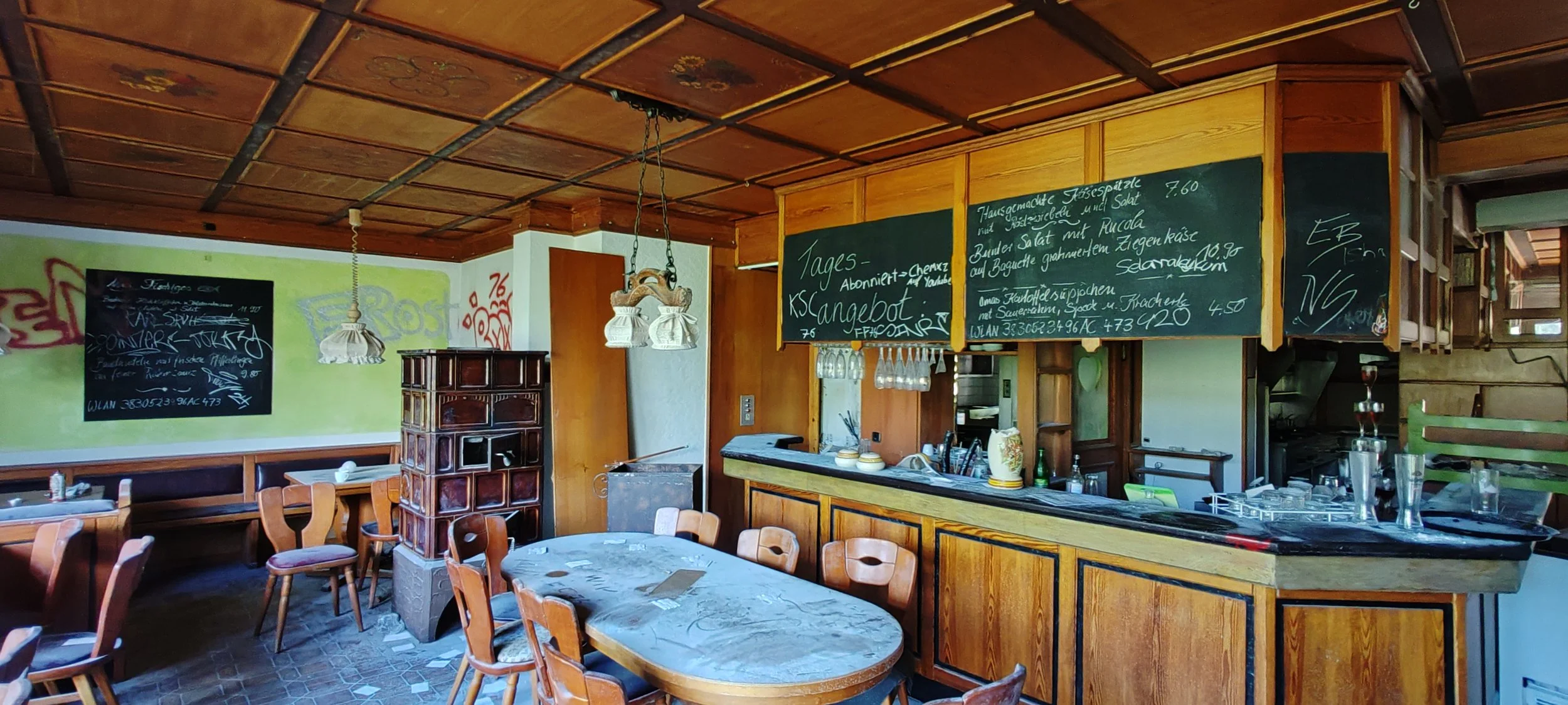 Blick durch ein Loch in einer bunten, verzierten Betonwand, mit dem Buchstaben 'YSL' erkennbar im Hintergrund.