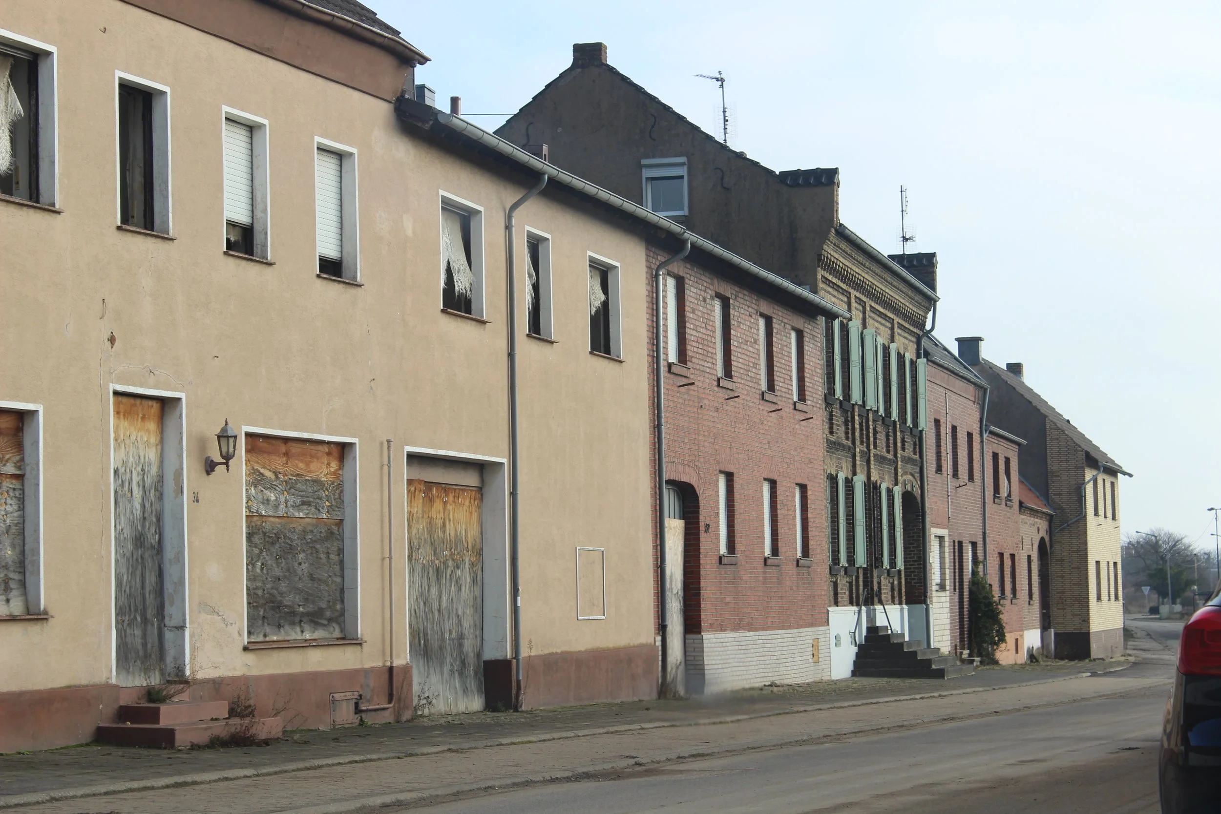 Verfallene Gebäude mit zerbrochenen Fenster und verschlossenen Türen entlang einer Straße