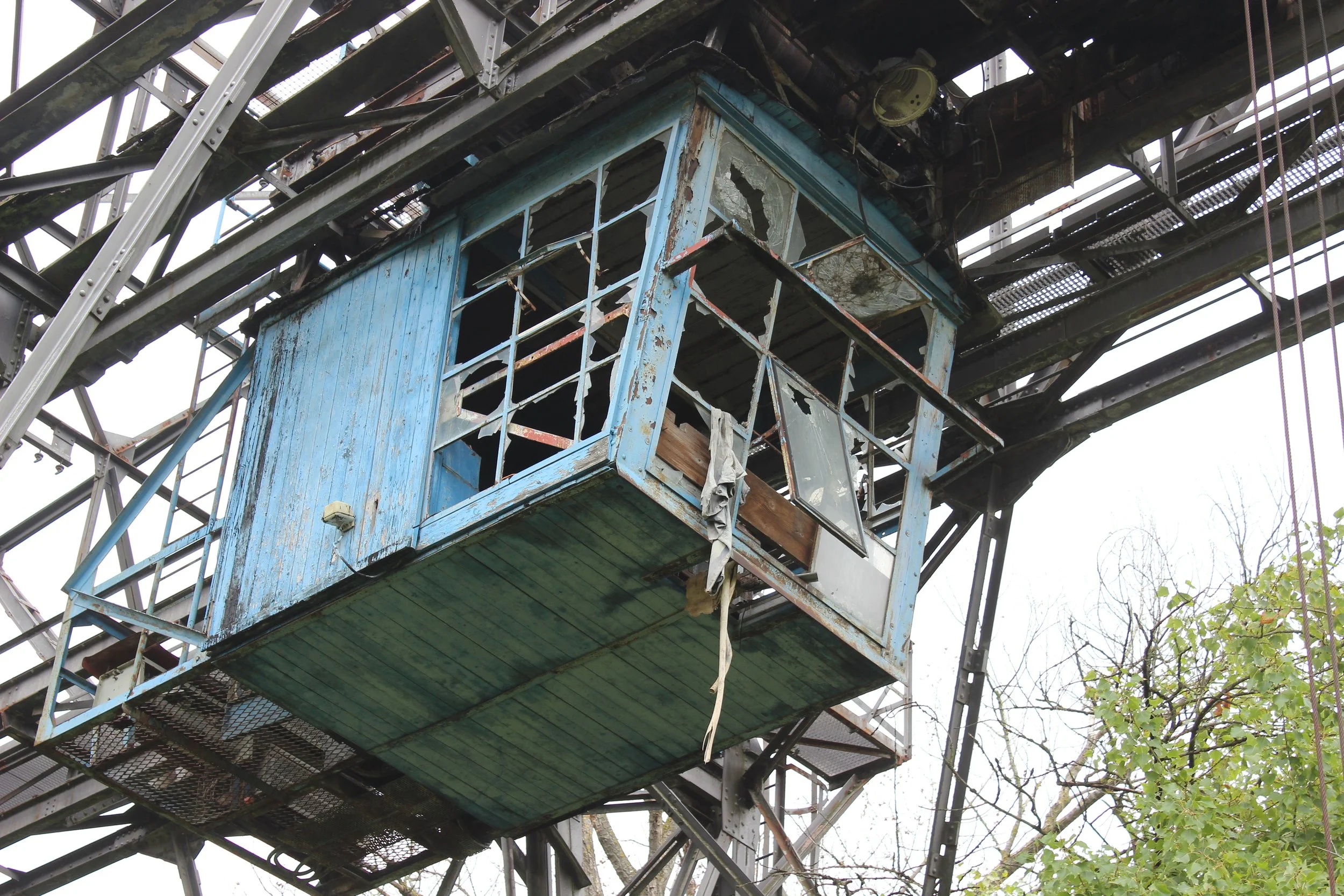 Verfallene, blaue Hütten in einer alten Eisenbahnbrücke, verwittert und beschädigt.