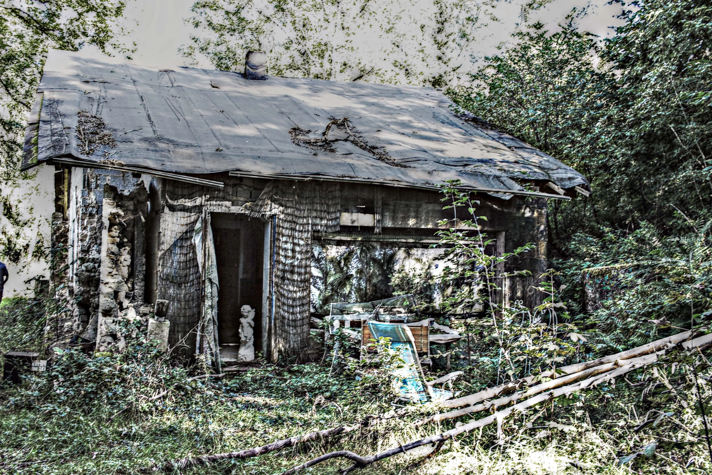 Verfallenes, baufälliges Haus im Wald, mit zerbrochenen Fenstern und überwucherten Pflanzen