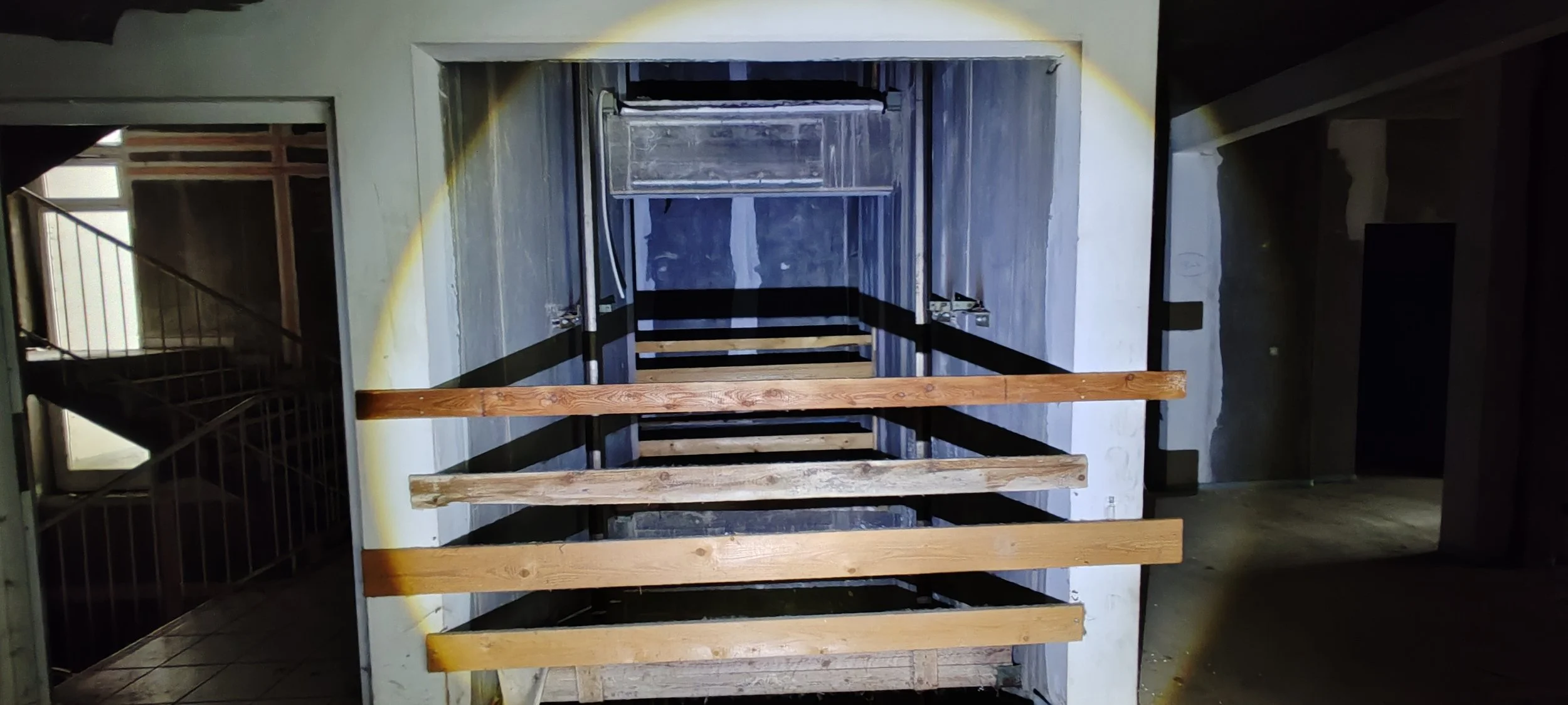 Aufzugsmechanismus mit Holzstangen in einem Gebäude, abgedeckt und unvollendet.