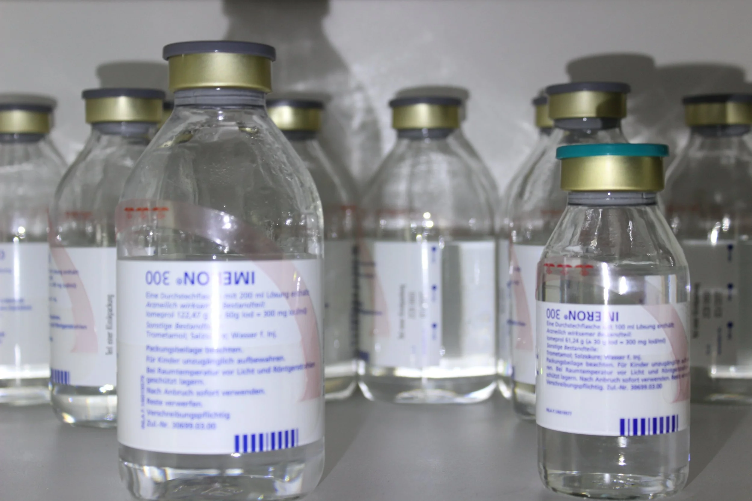 Mehrere leere medizinische Flaschen mit weißen Etiketten, in einer Reihenfolge aufgestellt.