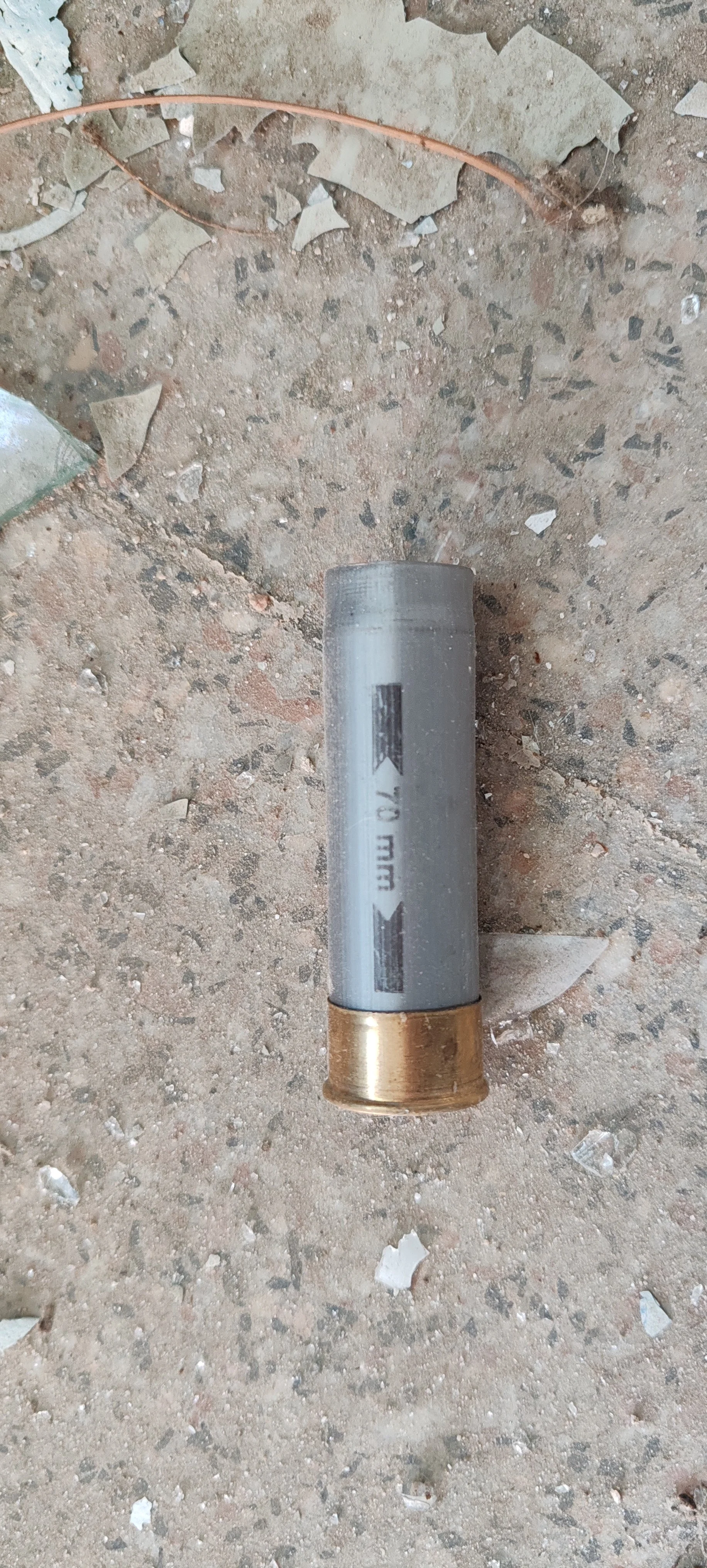 Eine Patronenhülse auf einem steinigen Boden.