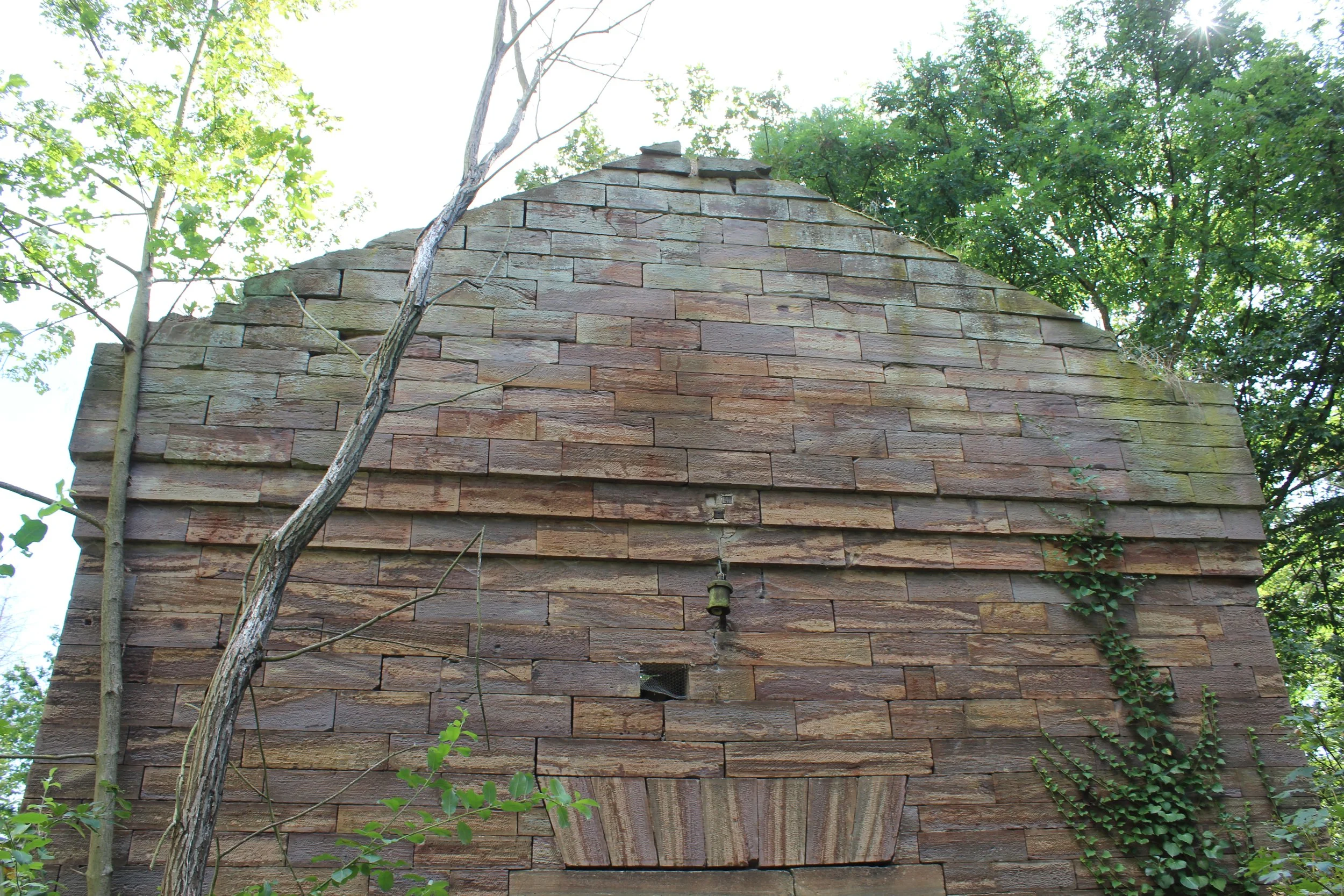 Alte brickhouse with ivy and trees around