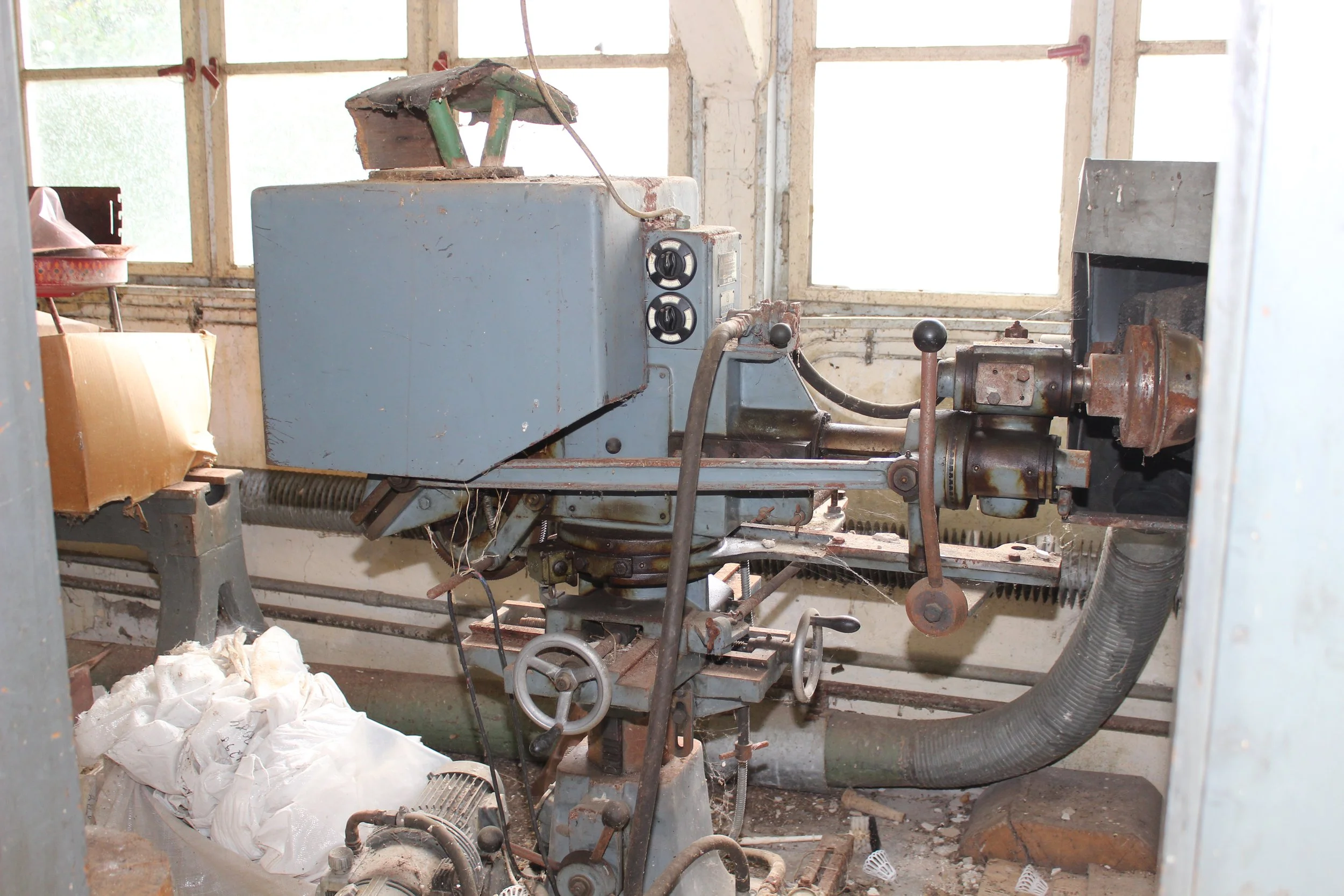 Altmaschine in einem alten Raum mit verstaubter Umgebung.