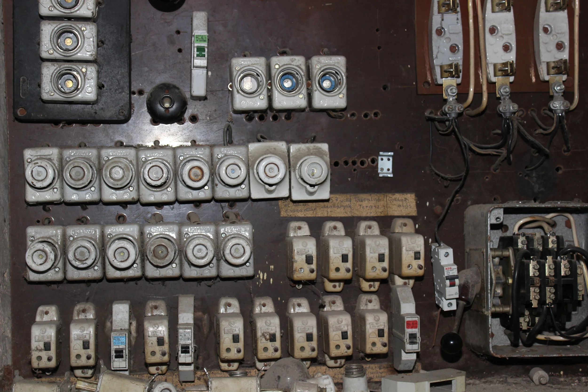 Alter Schaltschrank mit diversen gereinigten und verschmutzten elektrischen Schalter und Komponenten.