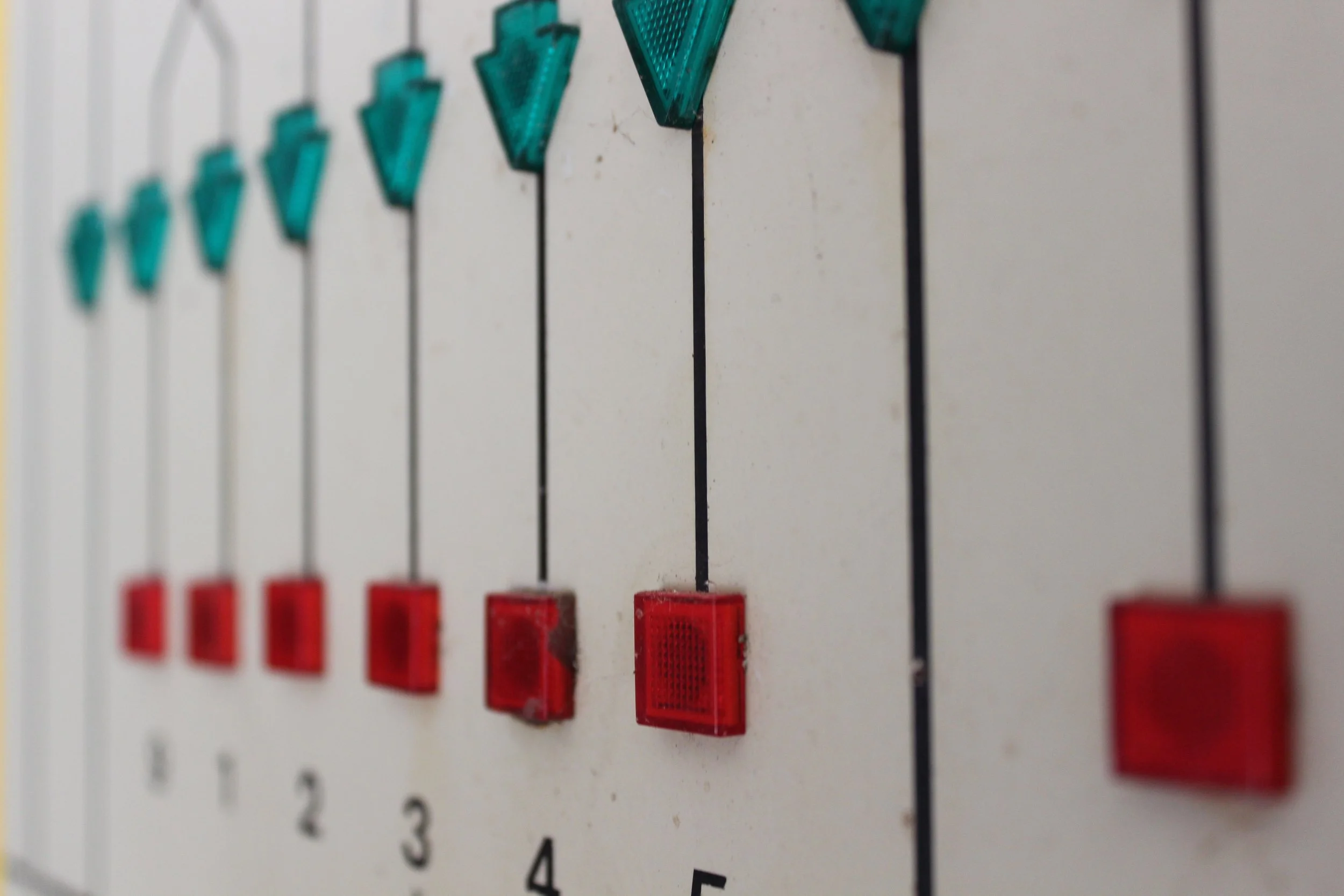 Nahaufnahme eines Steuerungspanels mit roten und blauen Schaltern, nummeriert von 1 bis 5.