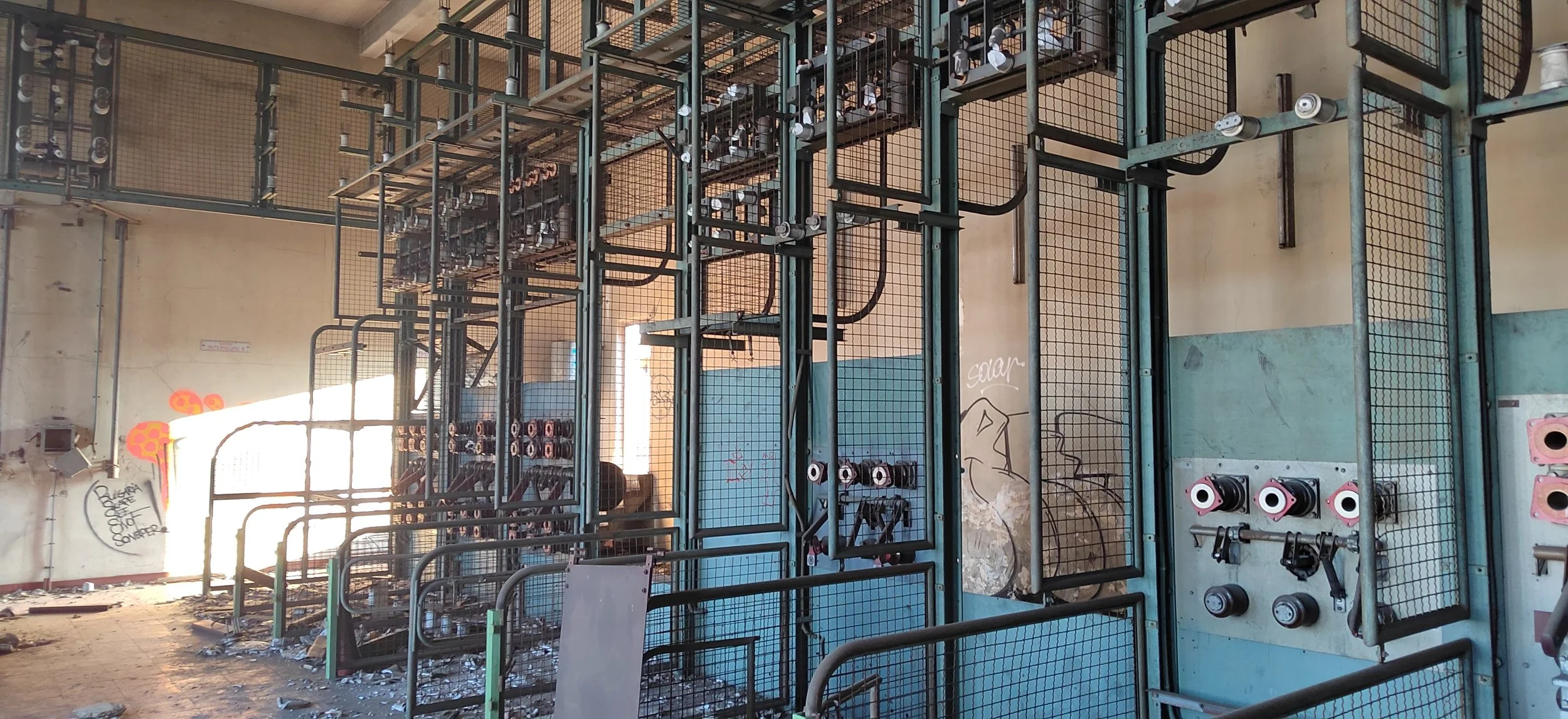 Verlassene, zerstörte Skaterampe mit Graffiti an den Wänden und Müll auf dem Boden.