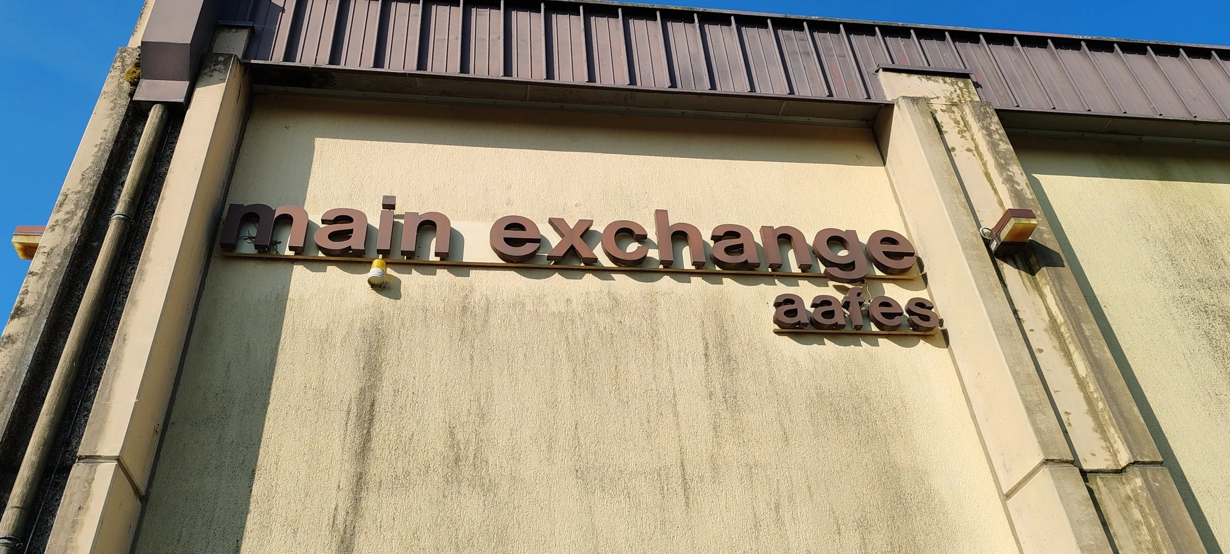 Außenansicht des Gebäudes mit einem Schild, das 'main exchange cafes' anzeigt, bei Tageslicht, gegen den Himmel.