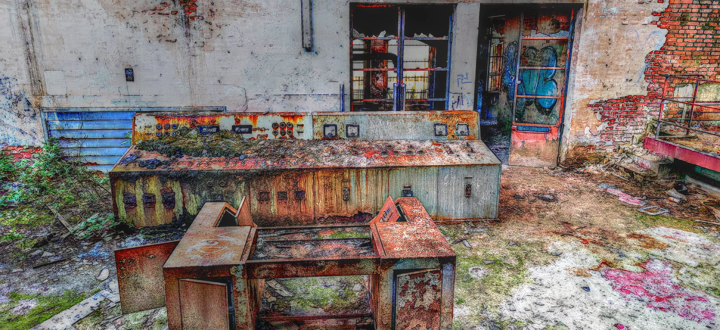 Verlassene, verrostete und beschädigte elektrische Steuerungskabine in einem verlassenen Gebäude mit grauer und roter Backsteinwand im Hintergrund, auf dem Boden liegen Brocken und Schmutz.