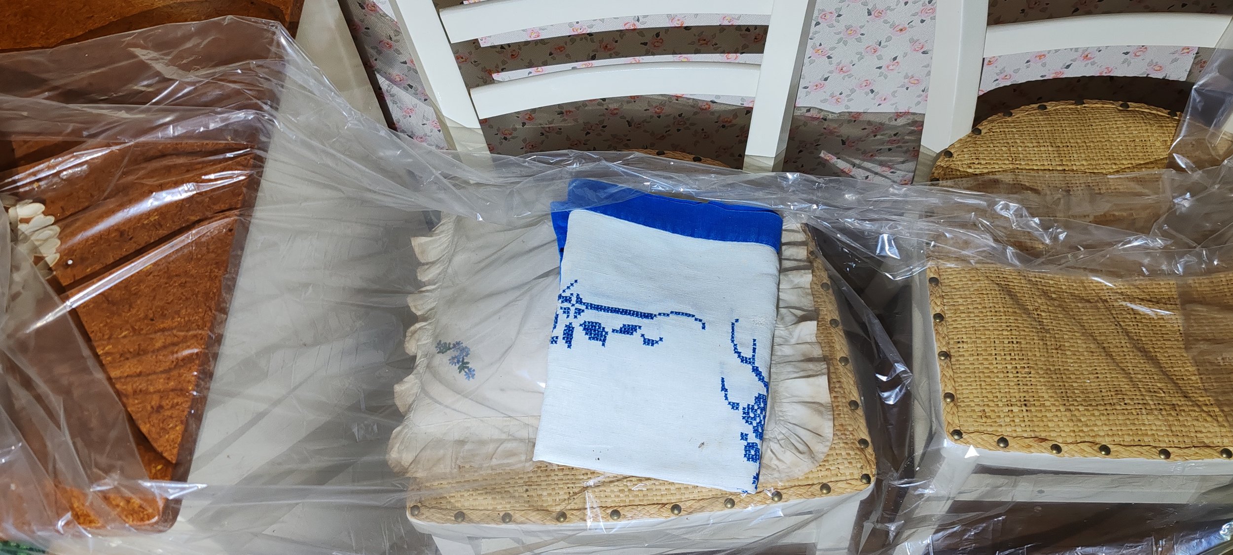 Verpackte Kekse, ein Stofftuch mit blauer Verzierung, ein Stuhl mit blumigem Bezug in einem Esszimmer.