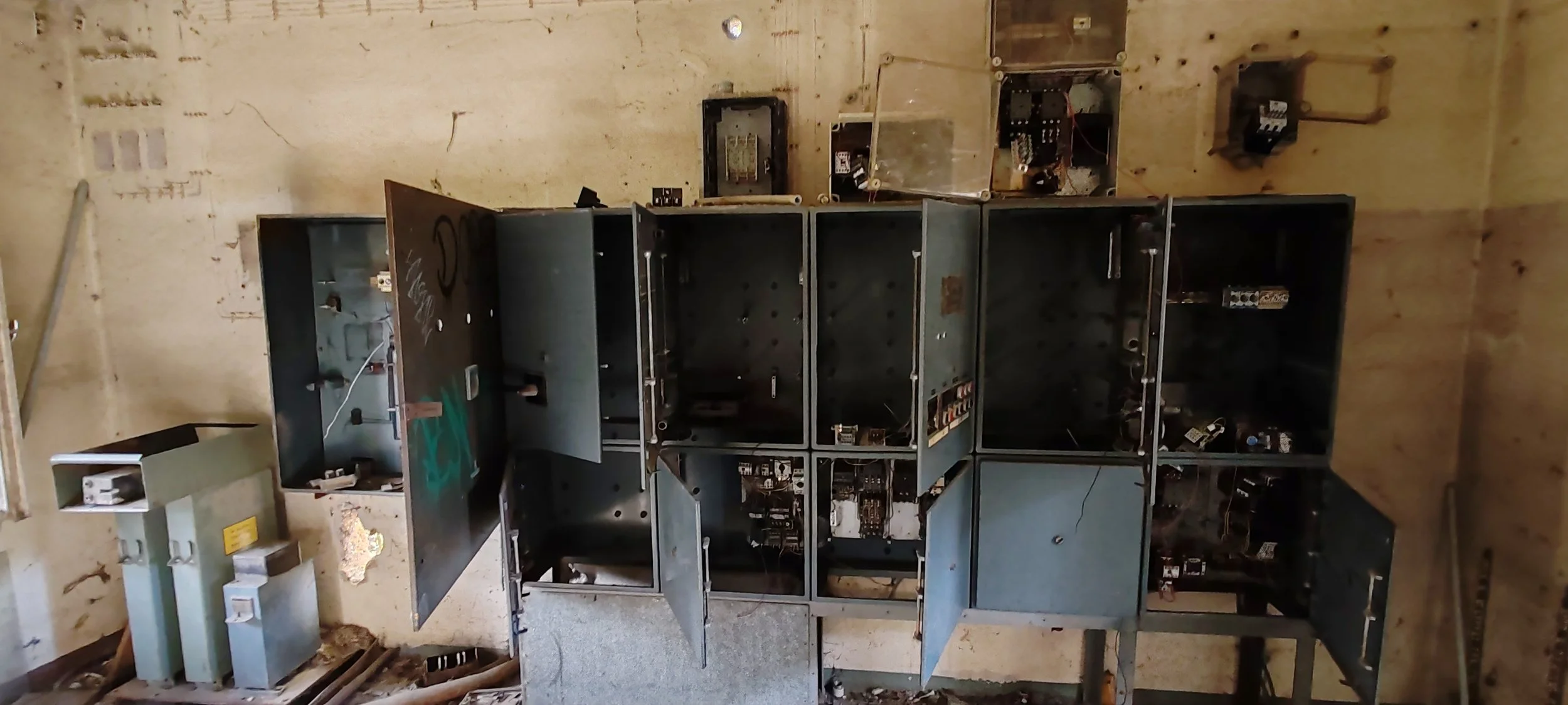 Verlassene, alte Zigarettenautomat in einem dunklen, verlassenen Raum mit staubigem Boden und zerbrochenen Wänden.