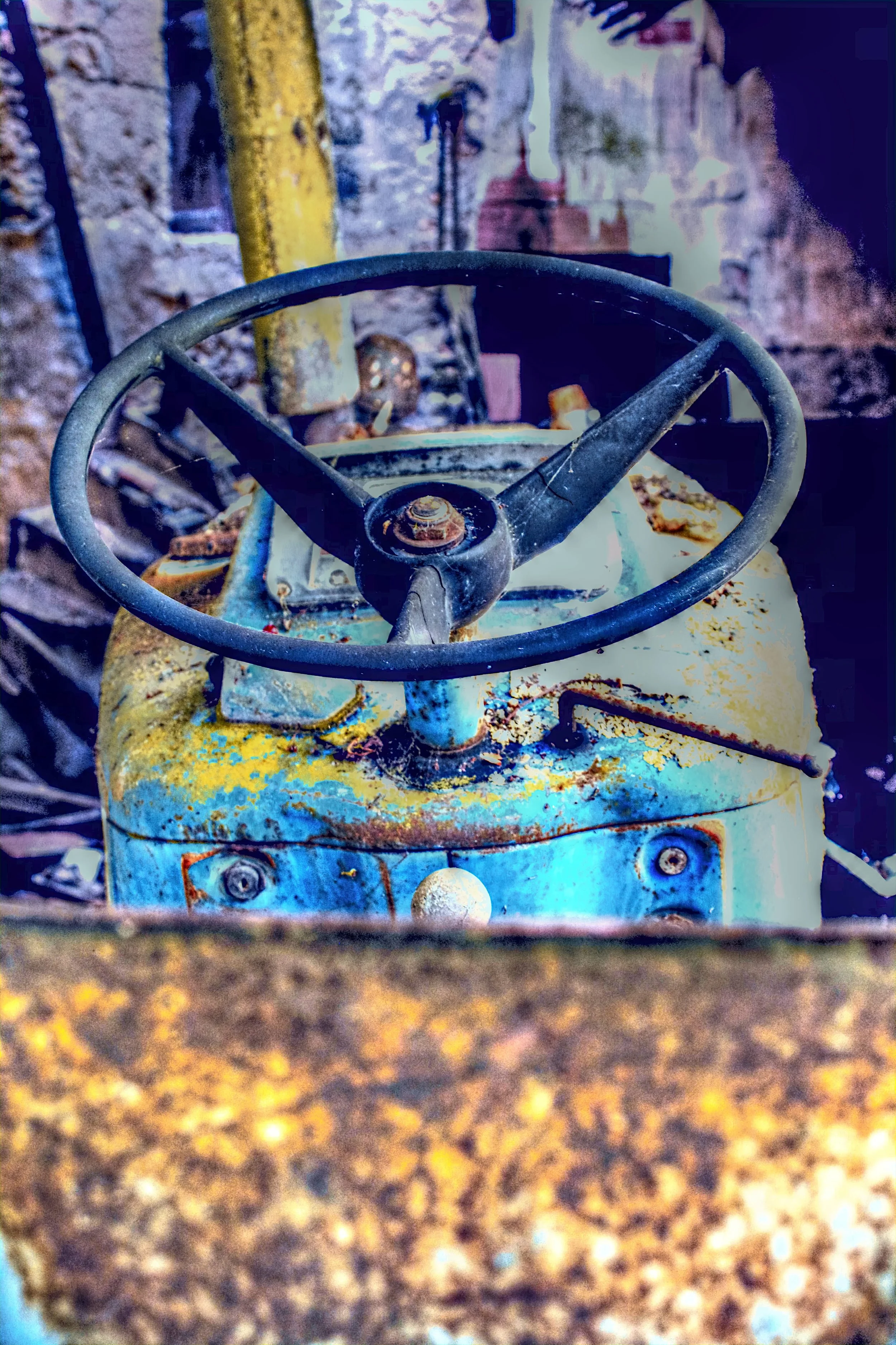 Ein verrosteter, alter Bagger mit einem großen, schwarzen Lenkrad in einer verlassenen, verfallenen Umgebung.