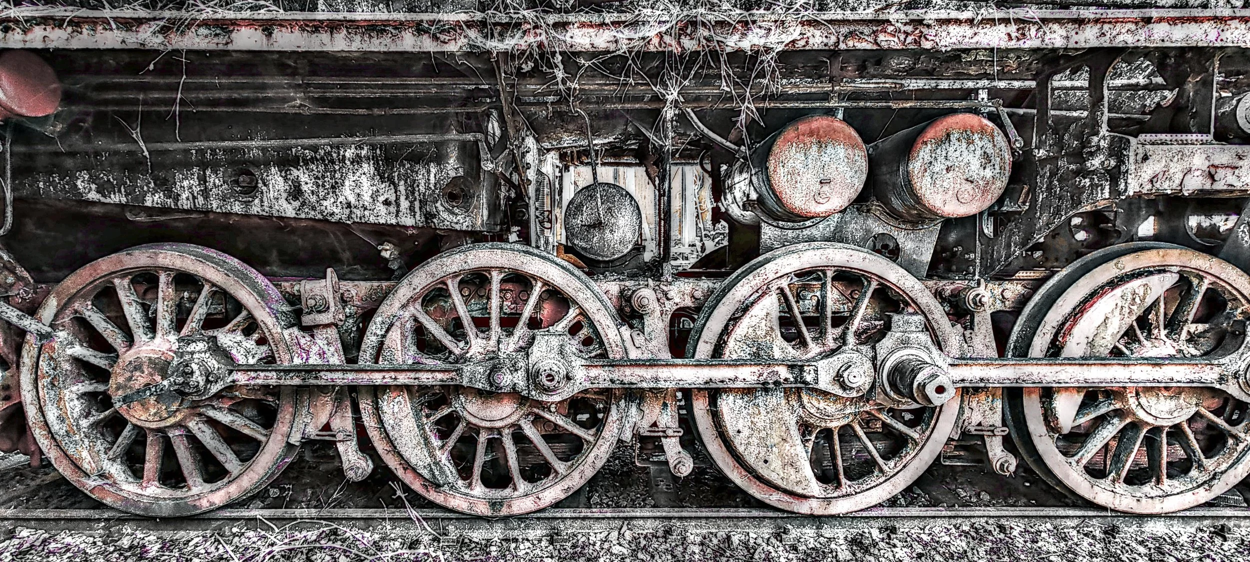Verrostete Dampflok mit sichtbaren Rädern und Antriebskomponenten, im Freien seit langem nicht benutzt.